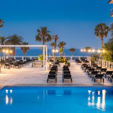 a pool with chairs and palm trees
