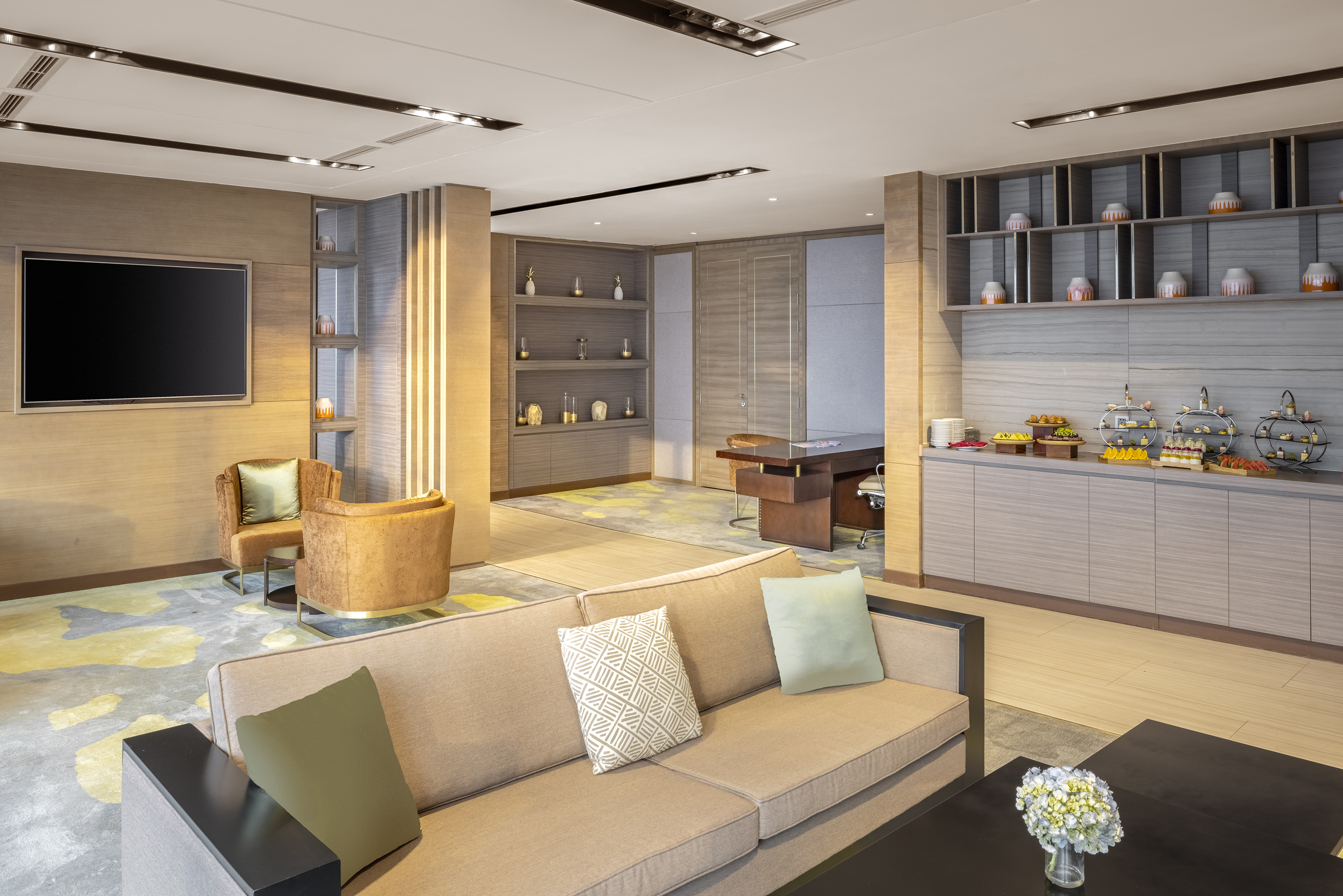 Modern hotel executive lounge with sofa, armchairs, TV, and buffet spread. - Déjate llevar por un mundo de distinción y atenciones exclusivas - Meliá Vinpearl Thanh Hoa, Thanh Hoa