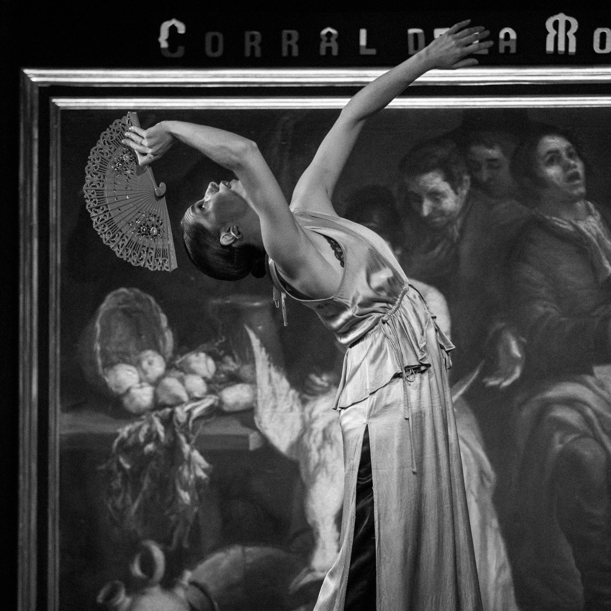 a woman in a dress holding a fan