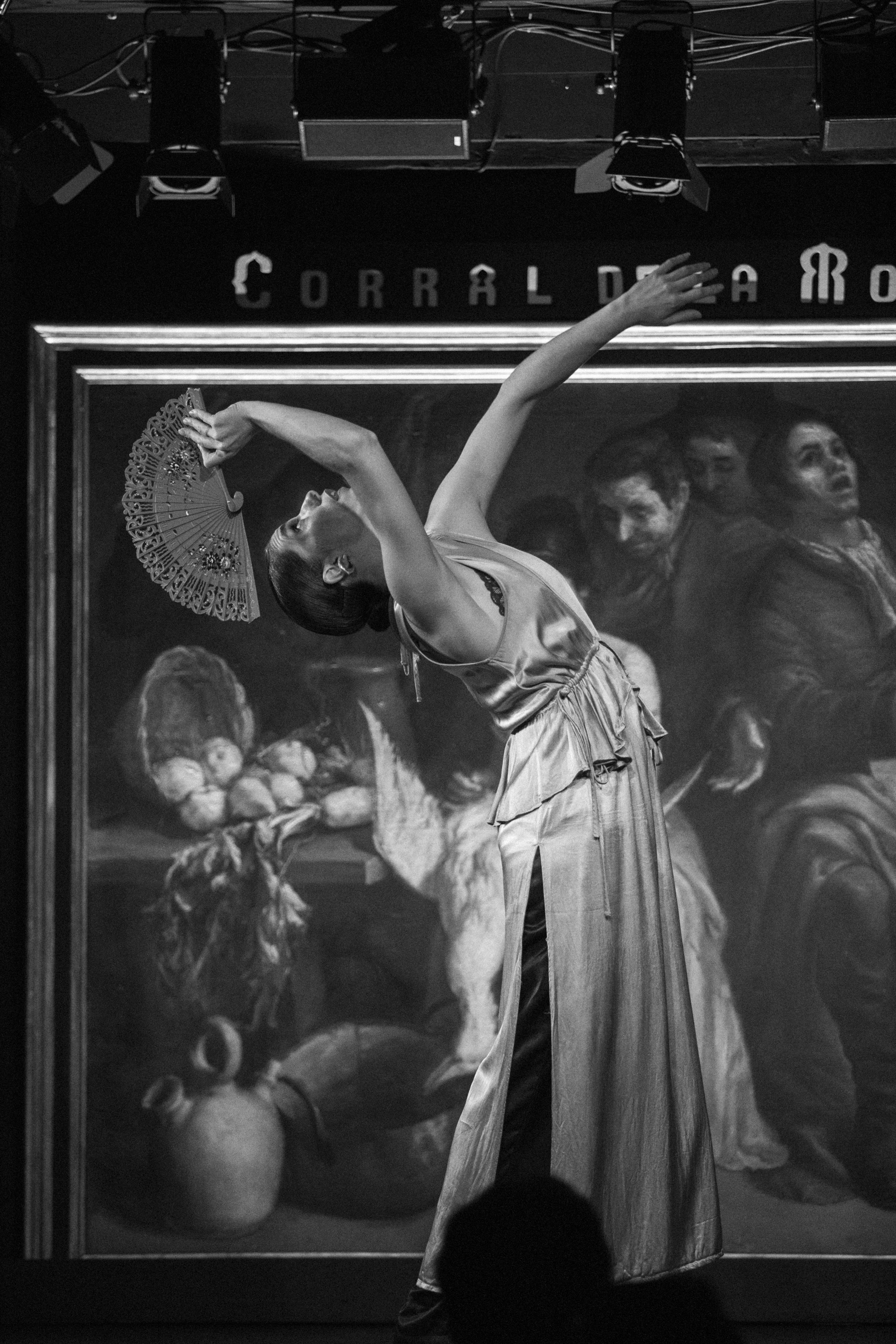 a woman in a dress holding a fan