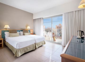 a room with two beds and a glass door