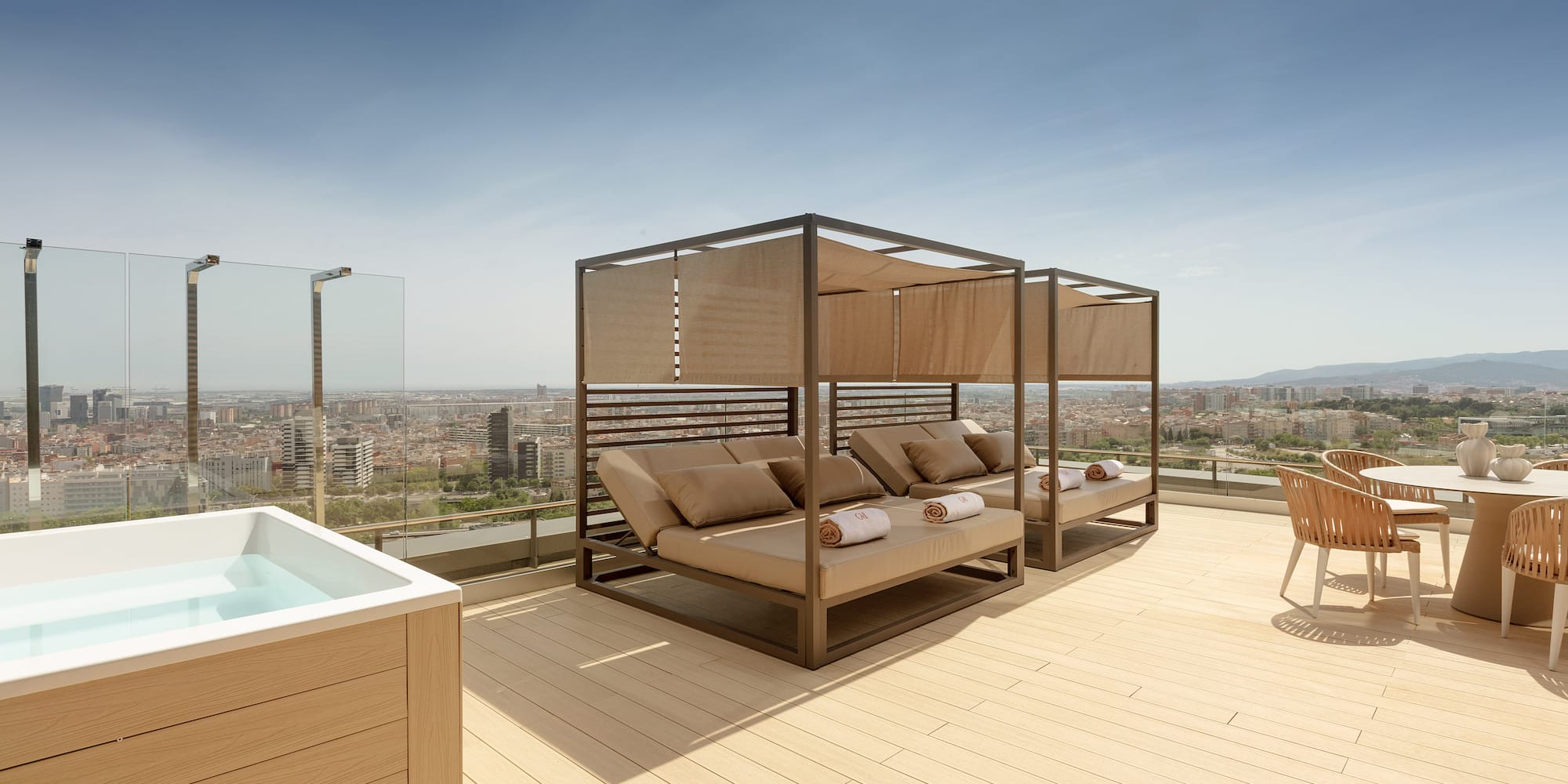 Rooftop terrace with hot tub, canopy daybeds, and city skyline view.
