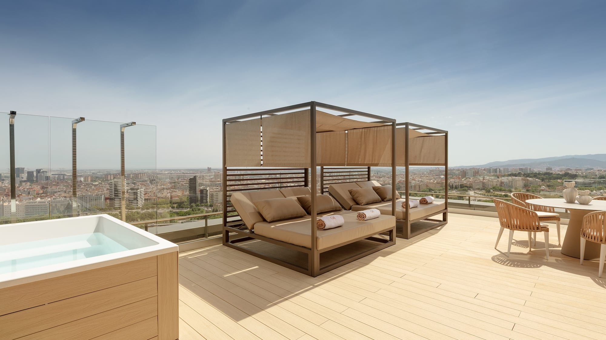 Rooftop terrace with hot tub, daybeds, and panoramic city views.