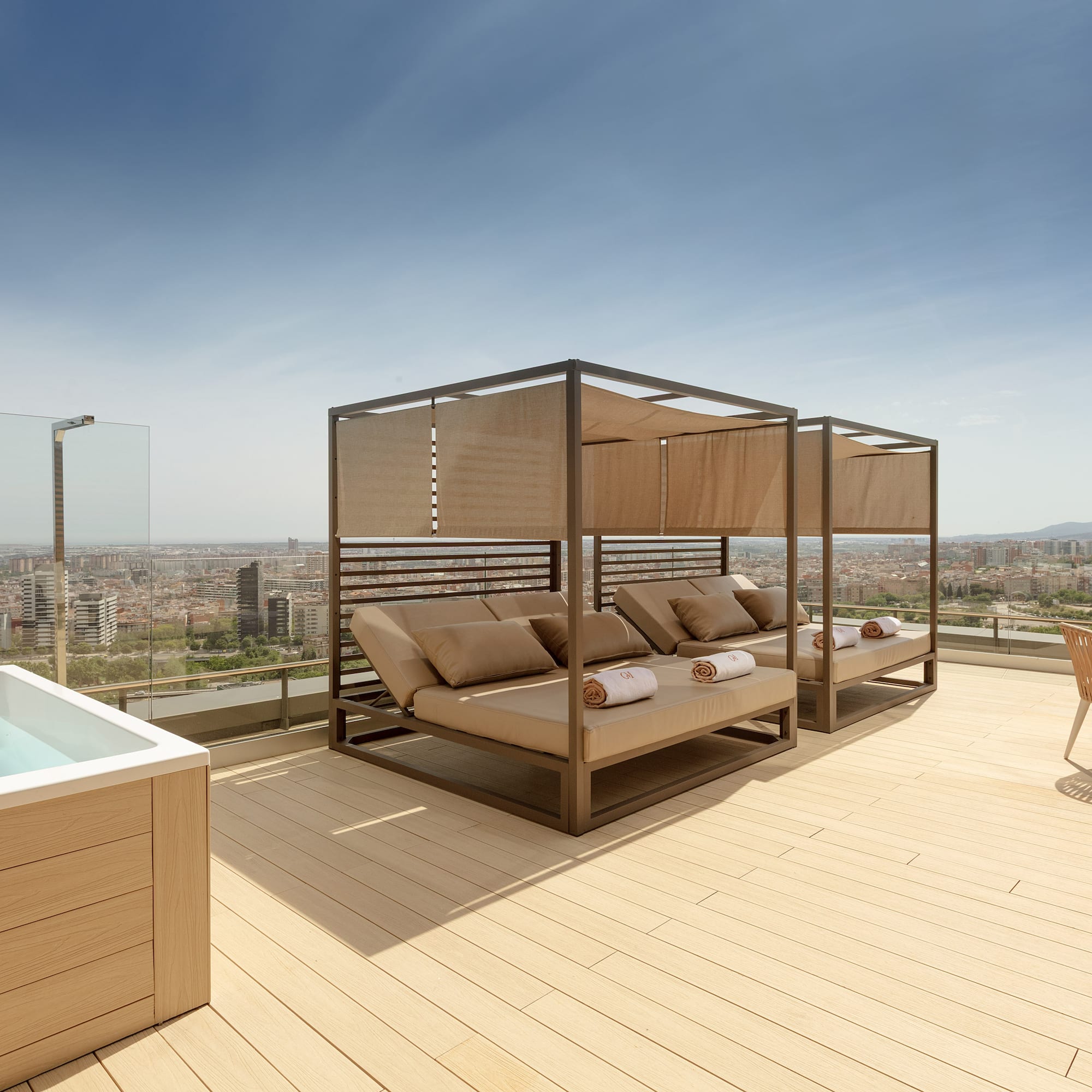 Rooftop terrace with hot tub, daybeds, and panoramic city views.