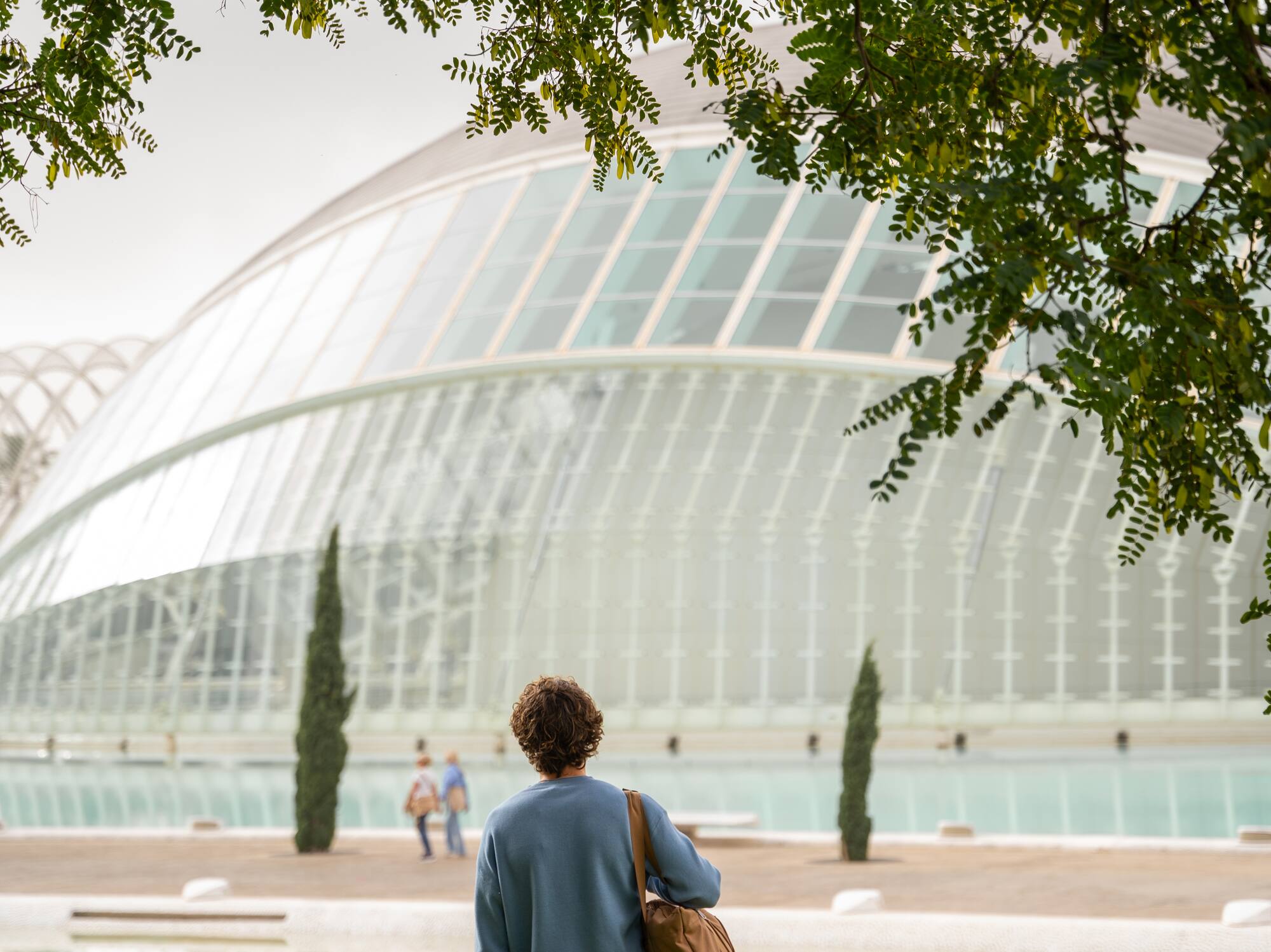 a person standing in front of a glass building