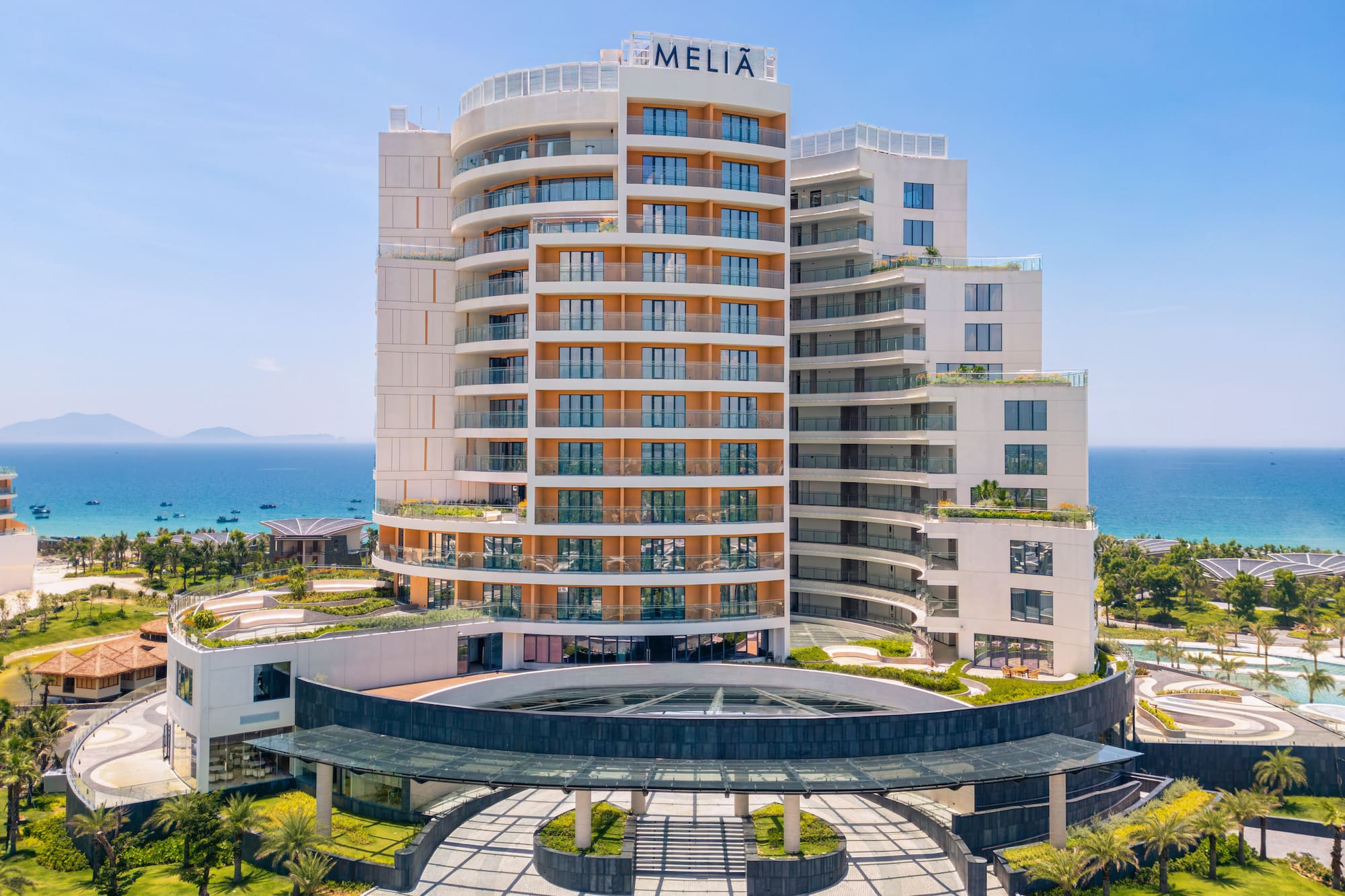 Melia oceanfront resort, modern building, grand entrance, lush palm trees.
