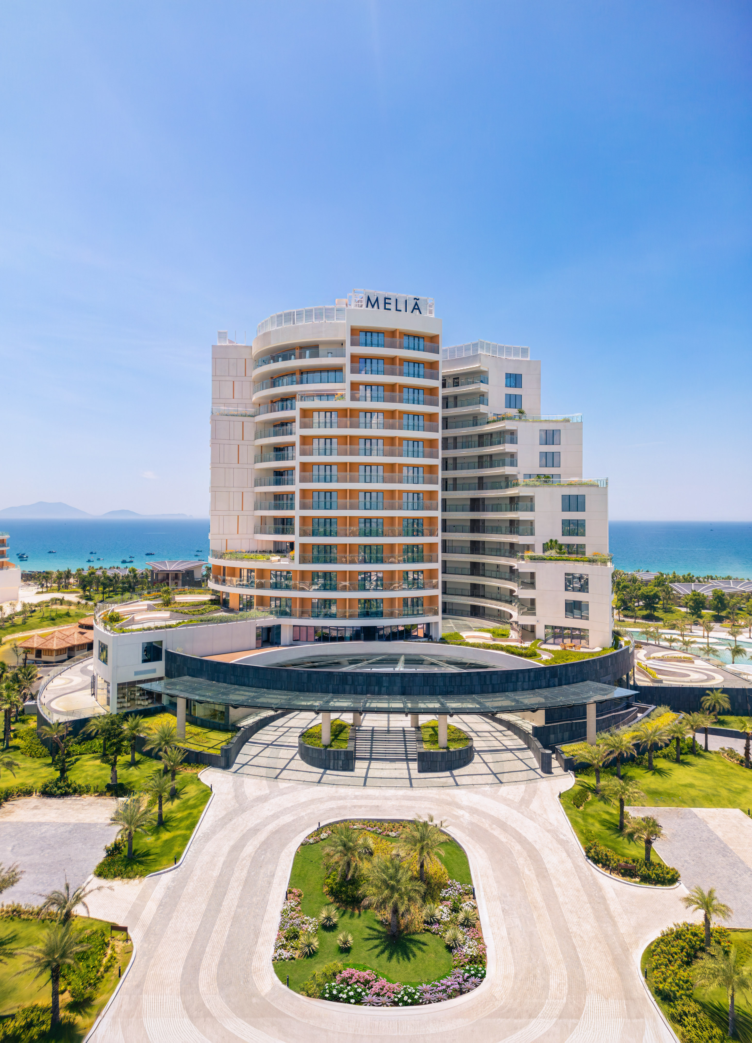 Melia oceanfront resort, modern building, grand entrance, lush palm trees.