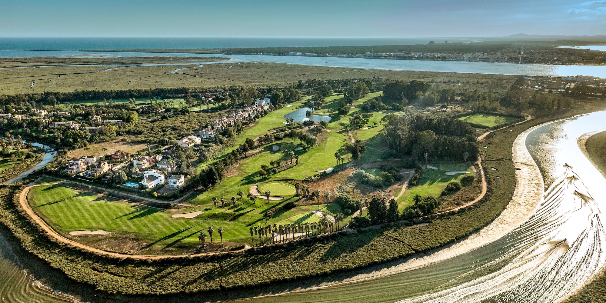 a landscape with a river and a green field