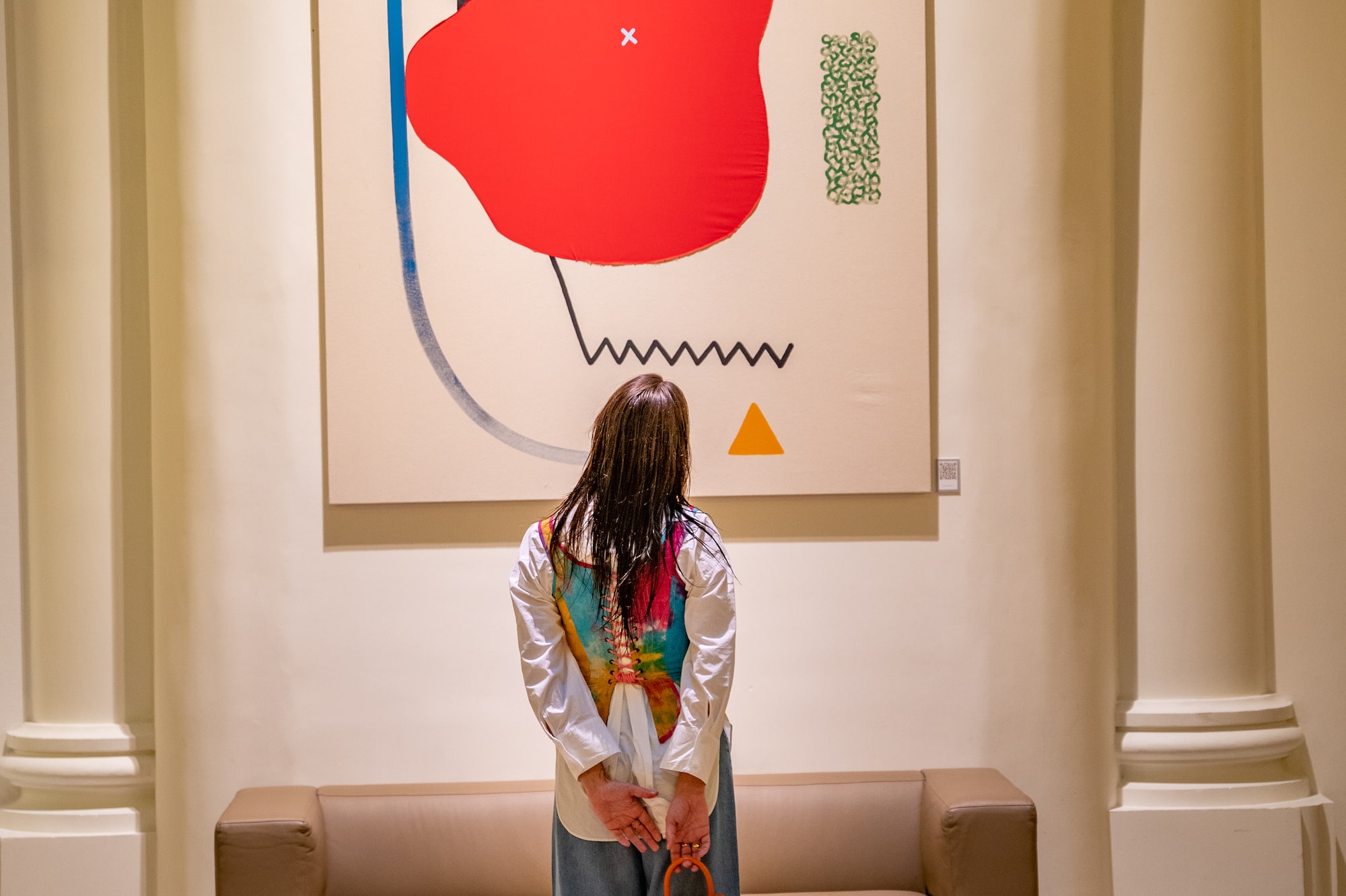 a woman standing in front of a painting