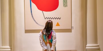 a woman standing in front of a painting
