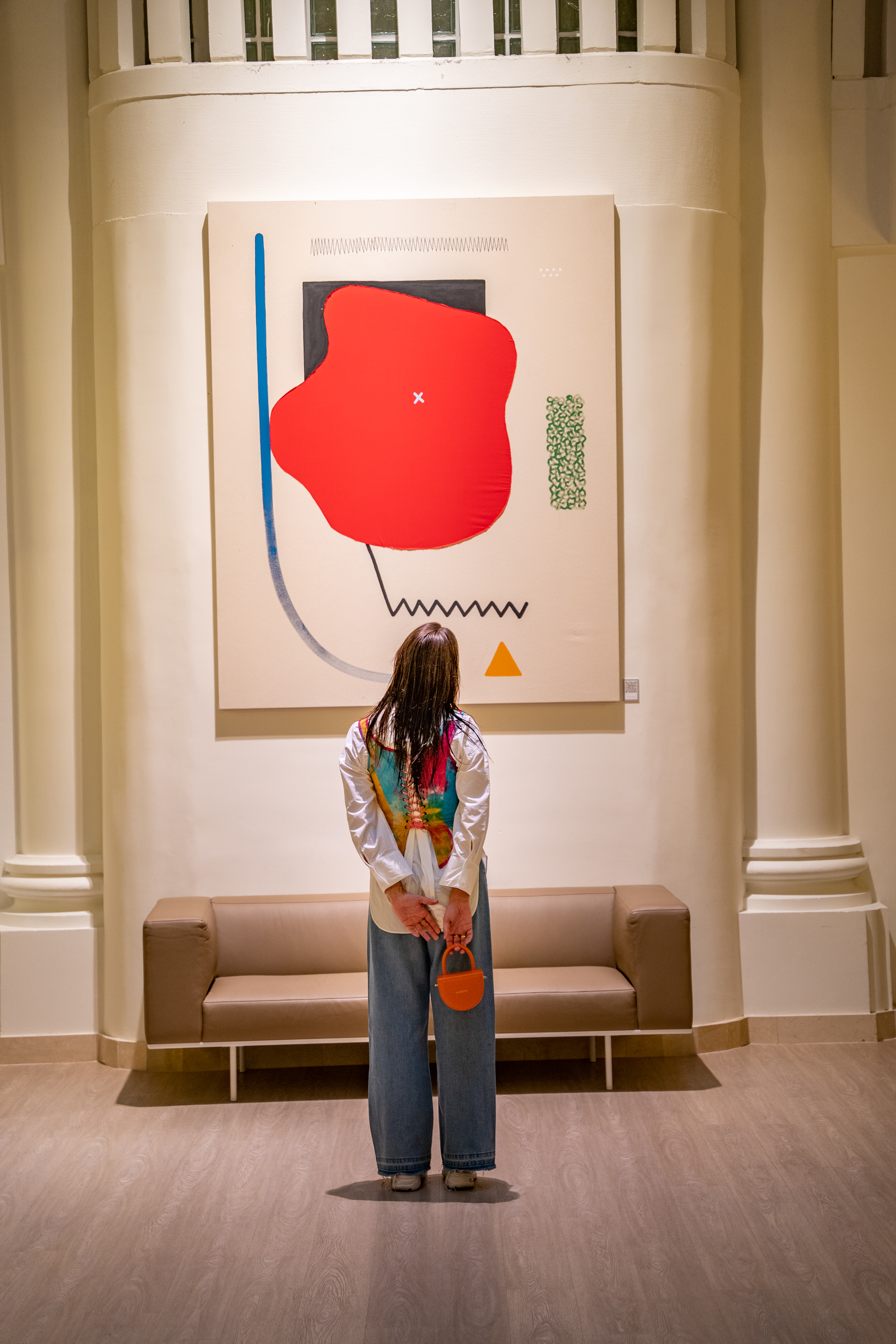 a woman standing in front of a painting