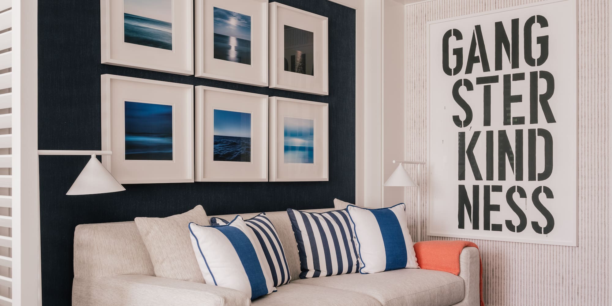 a couch with pillows and a lamp in a room with art on the wall