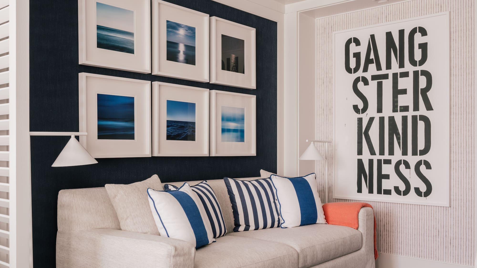 a couch with pillows and a lamp in a room with art on the wall