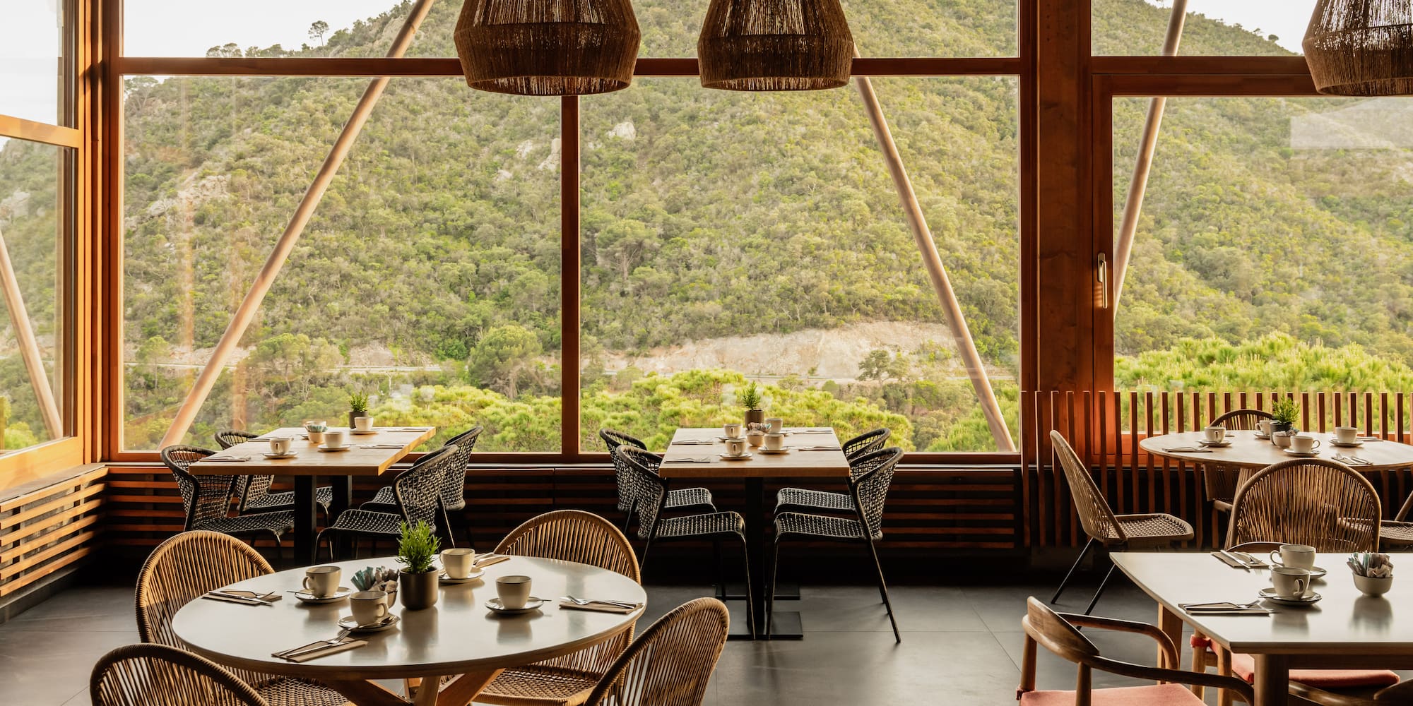 a room with tables and chairs and a view of the mountains