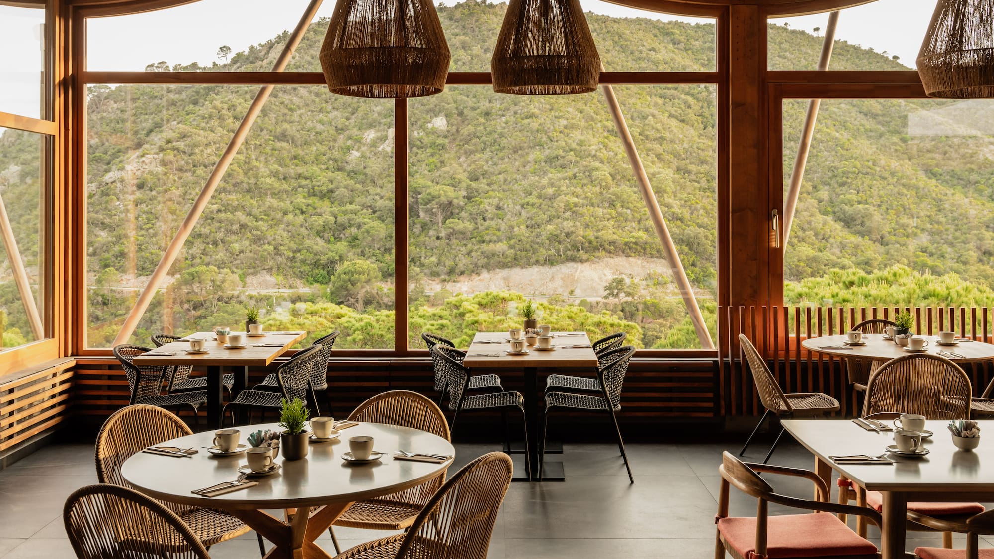 a room with tables and chairs and a view of the mountains