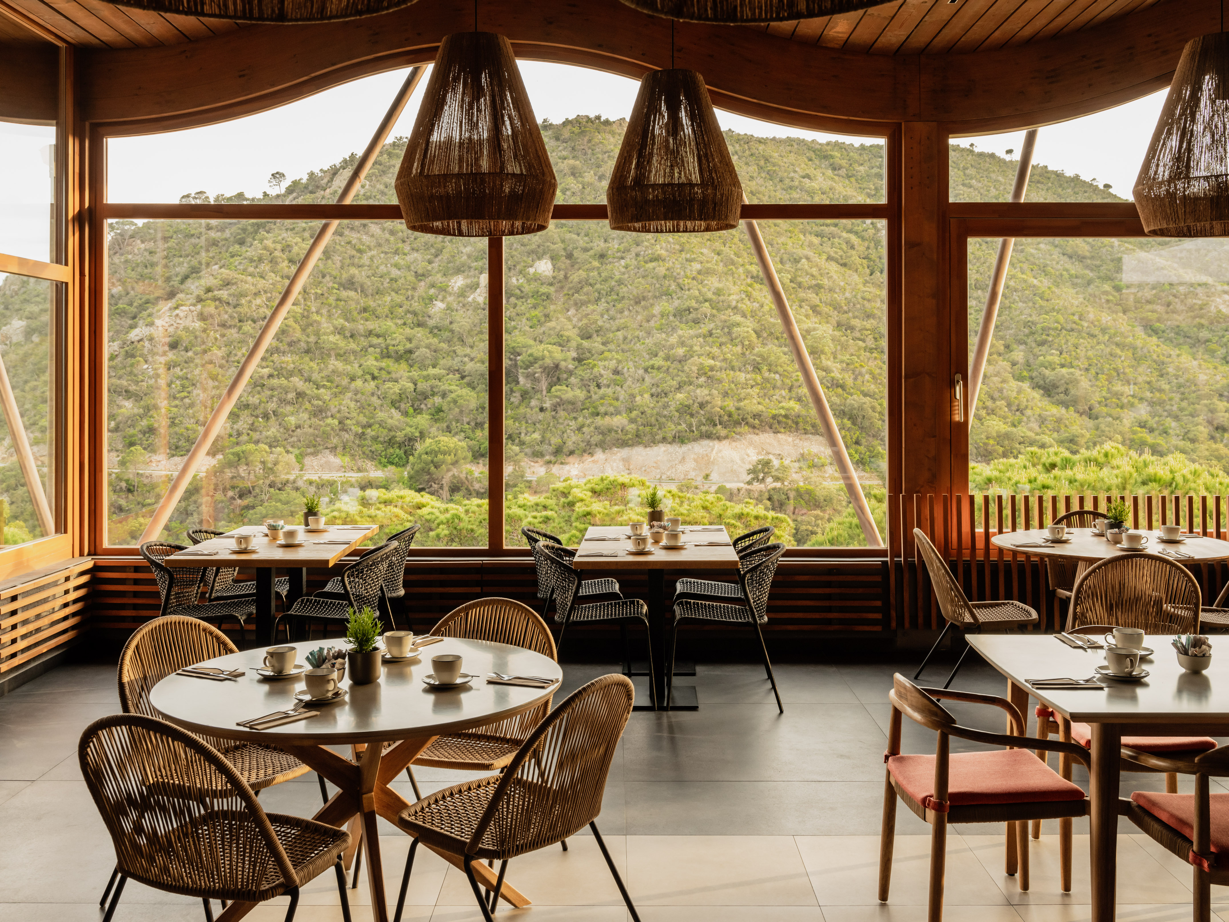Mountain view restaurant with wooden decor and set dining tables.