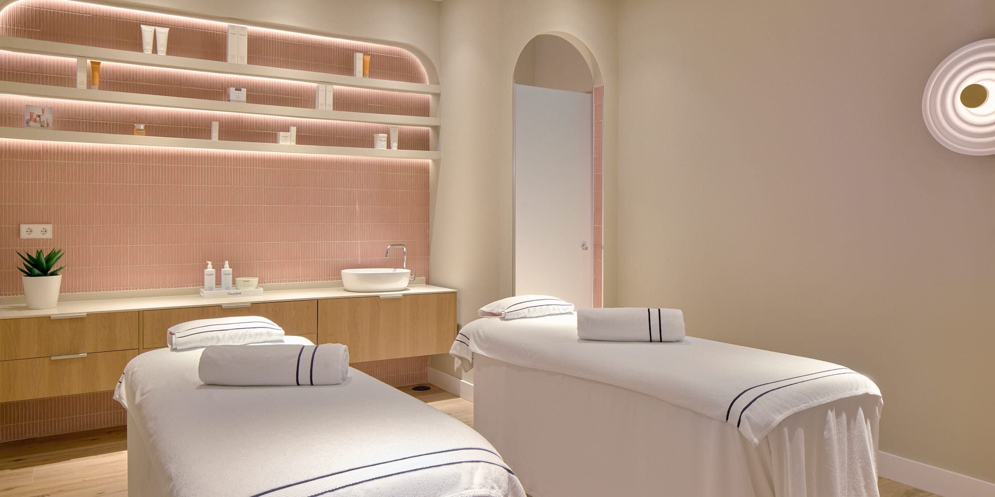 a room with beds and pink tile walls