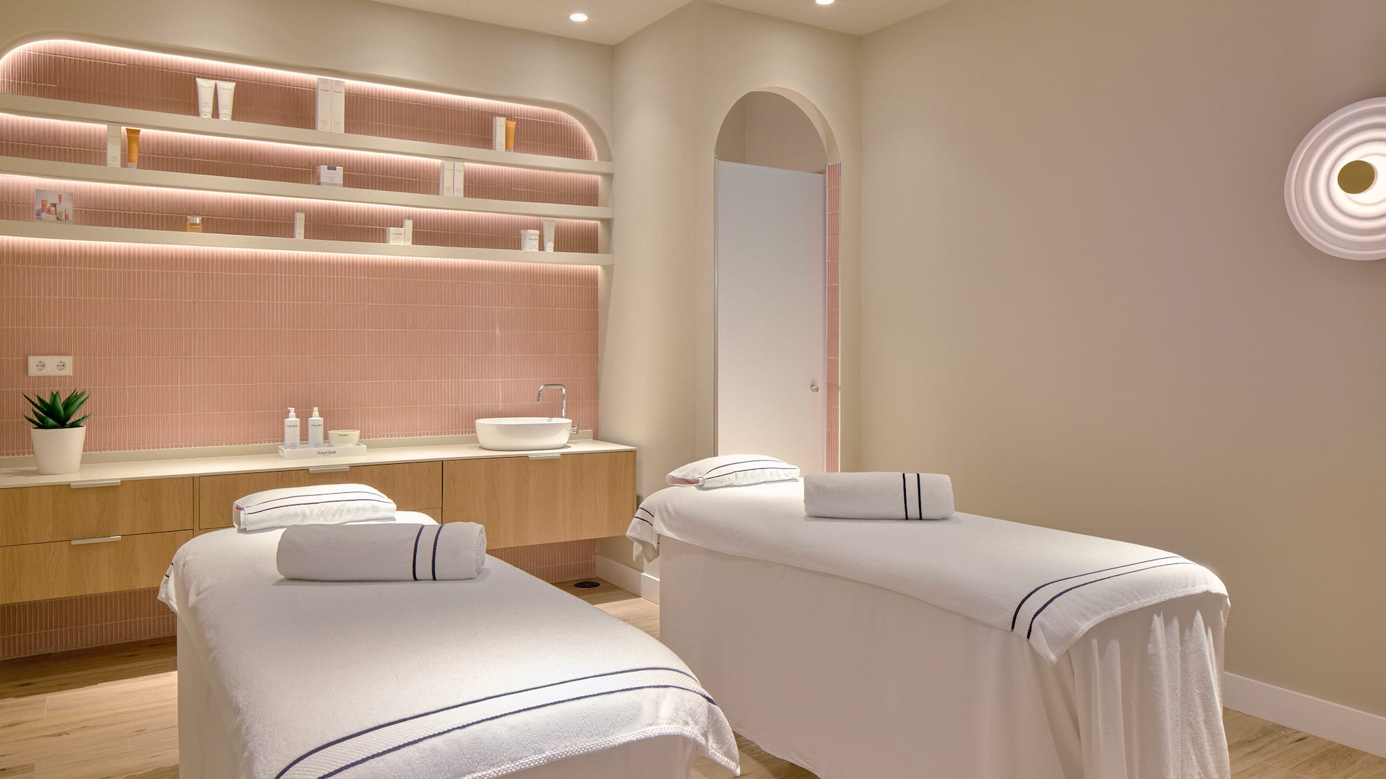 a room with beds and pink tile walls