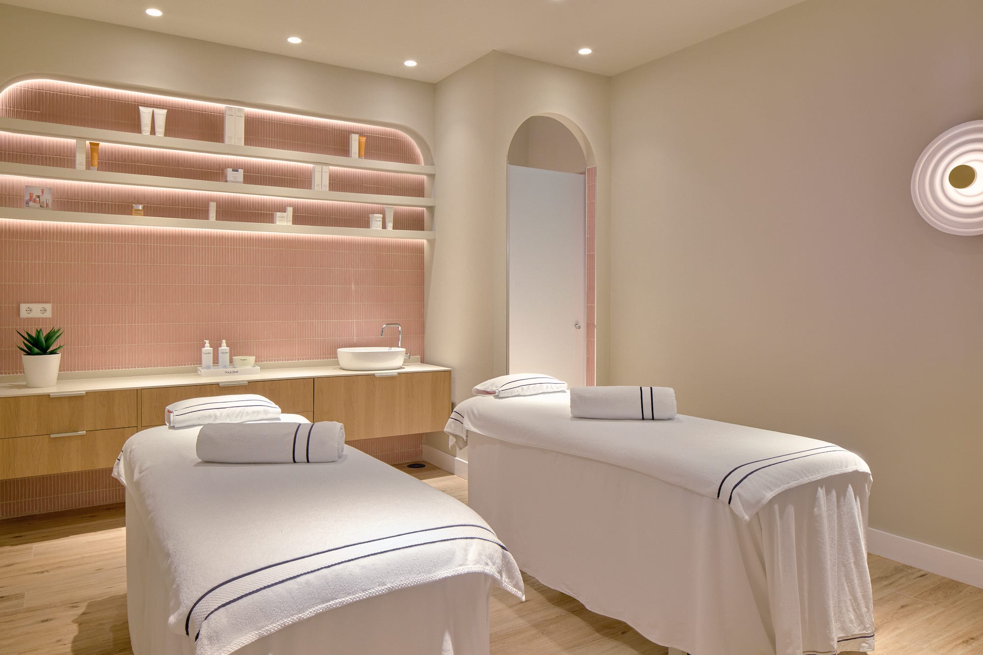 a room with beds and pink tile walls