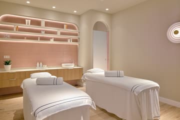 a room with beds and pink tile walls