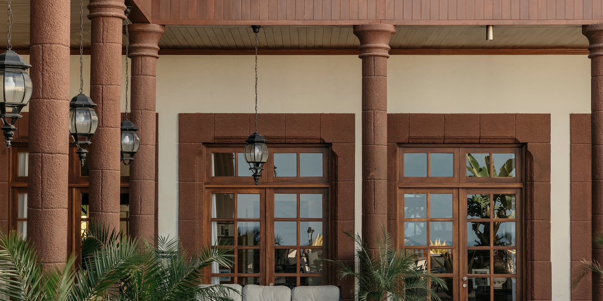 Hotel patio with outdoor seating, wooden balconies, and stone columns.