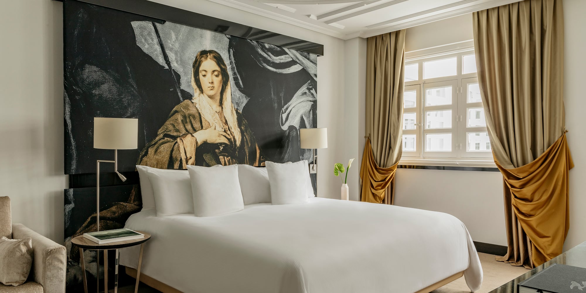 a bed with a large painting on the wall