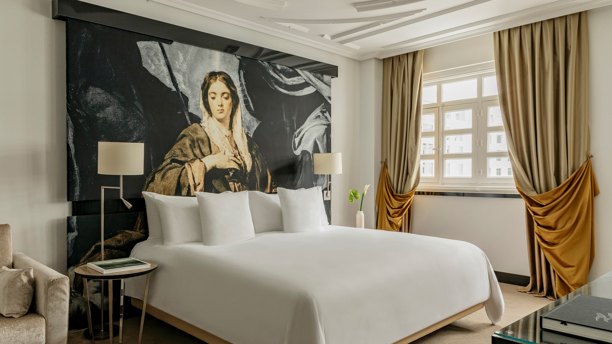 a bed with a large painting on the wall