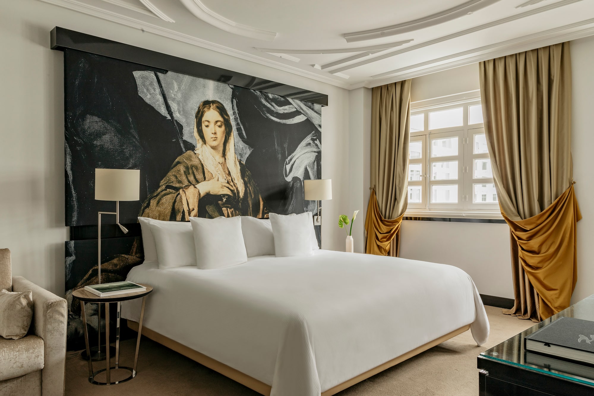 a bed with a large painting on the wall