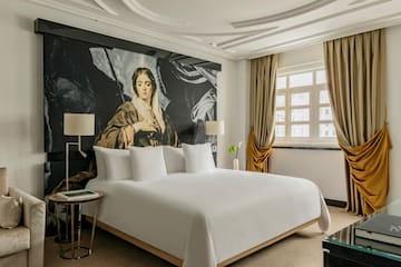 a bed with a large painting on the wall