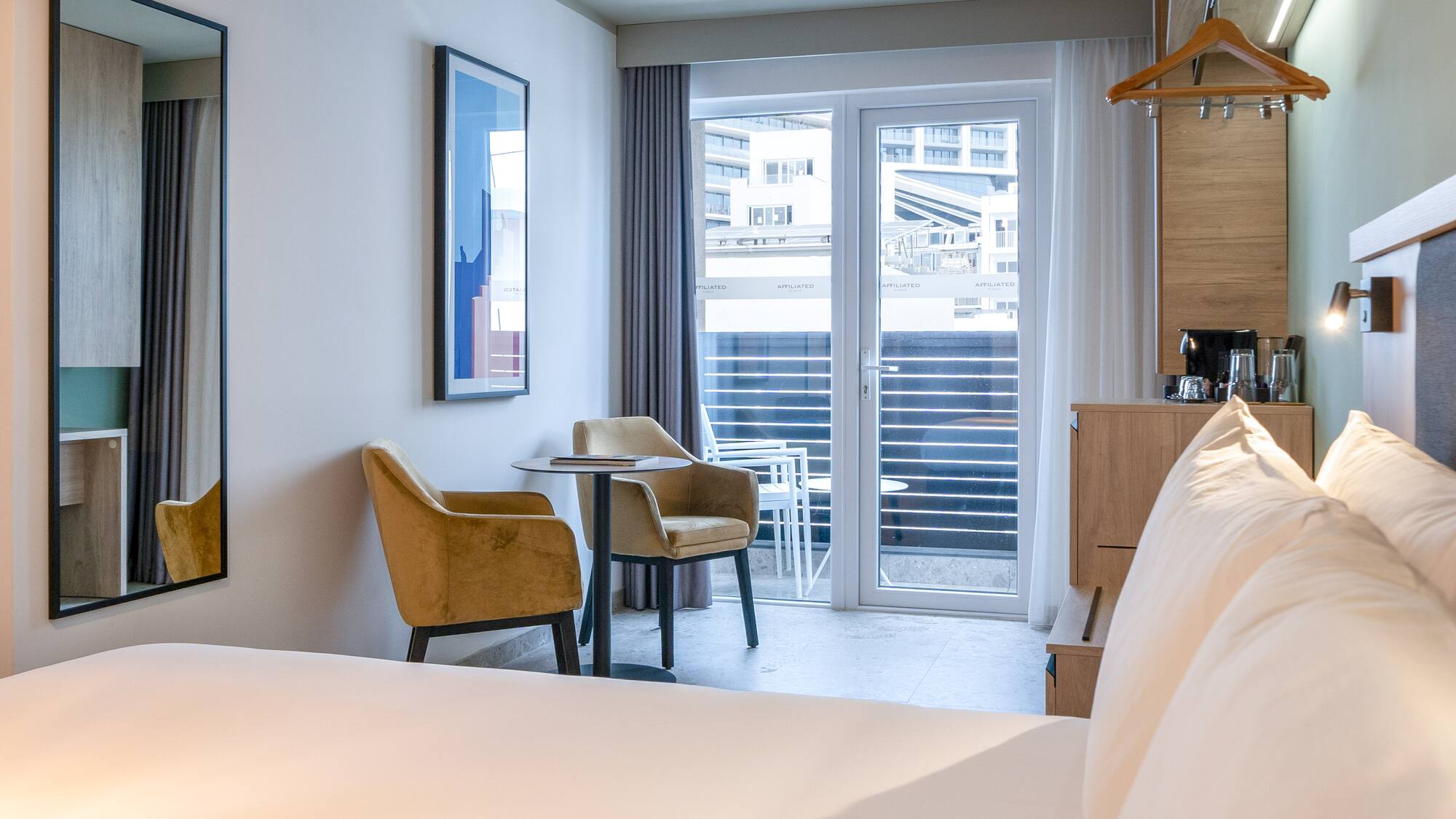 a room with a bed and chairs