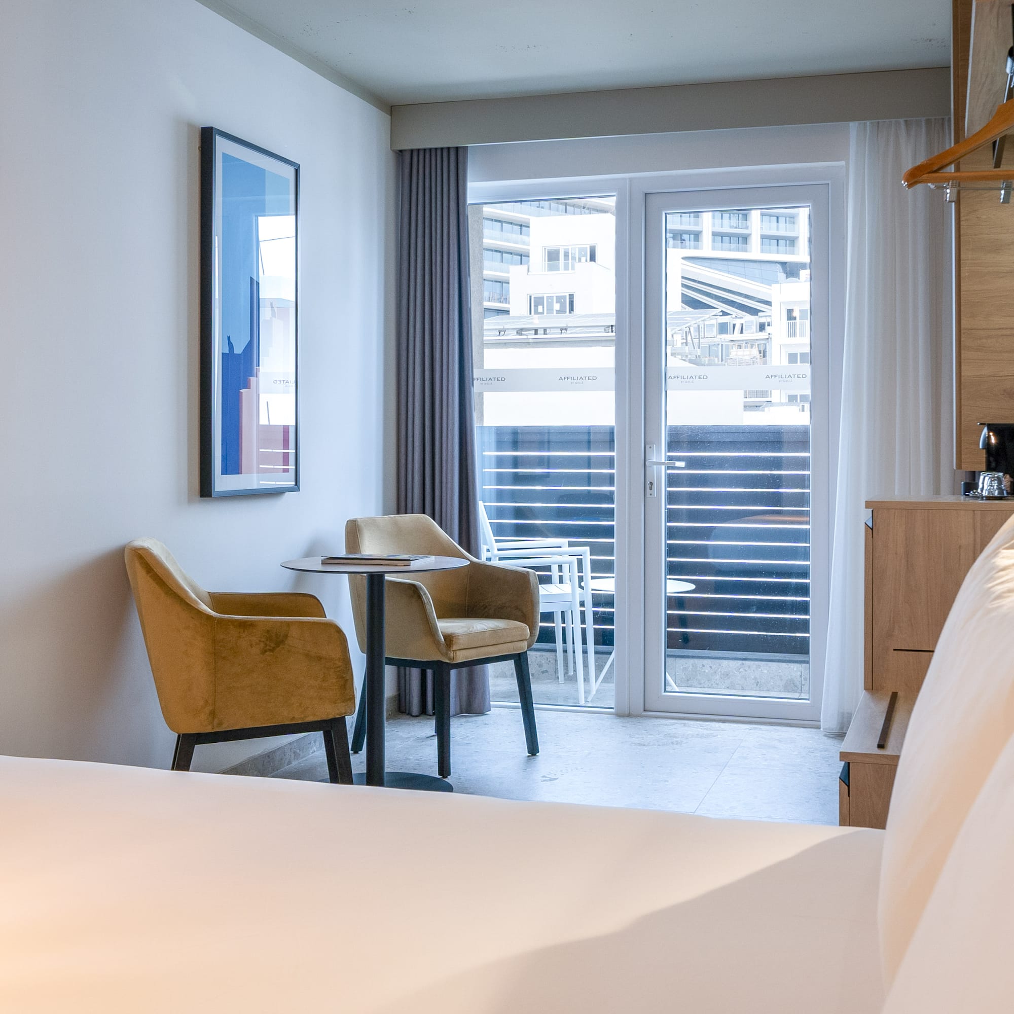 a room with a bed and chairs