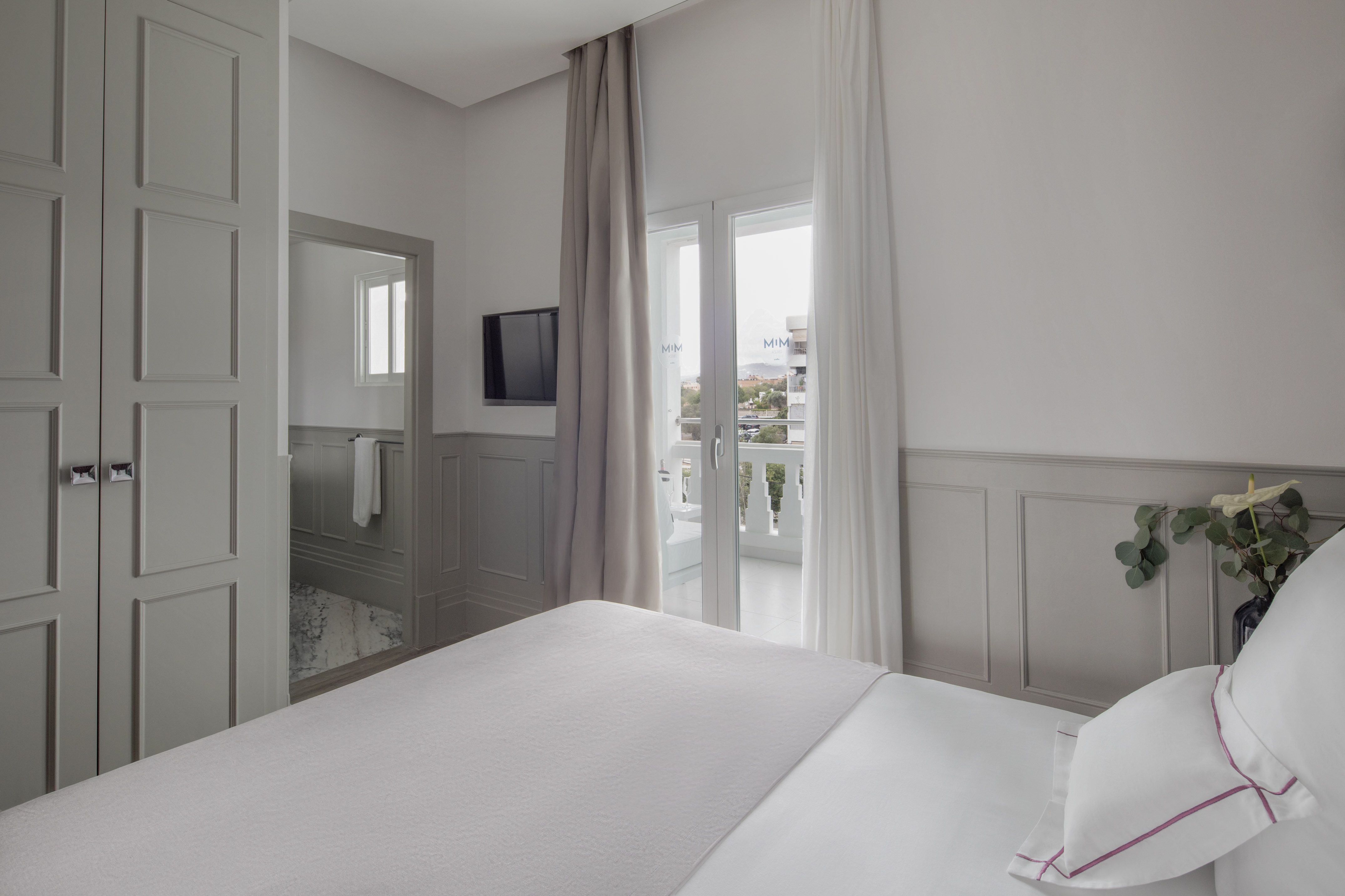 a bed in a room with a television and a balcony