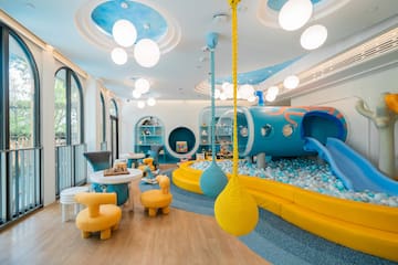 a room with a play area and a play area with a slide and balls