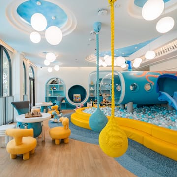 a room with a play area and a play area with a slide and balls