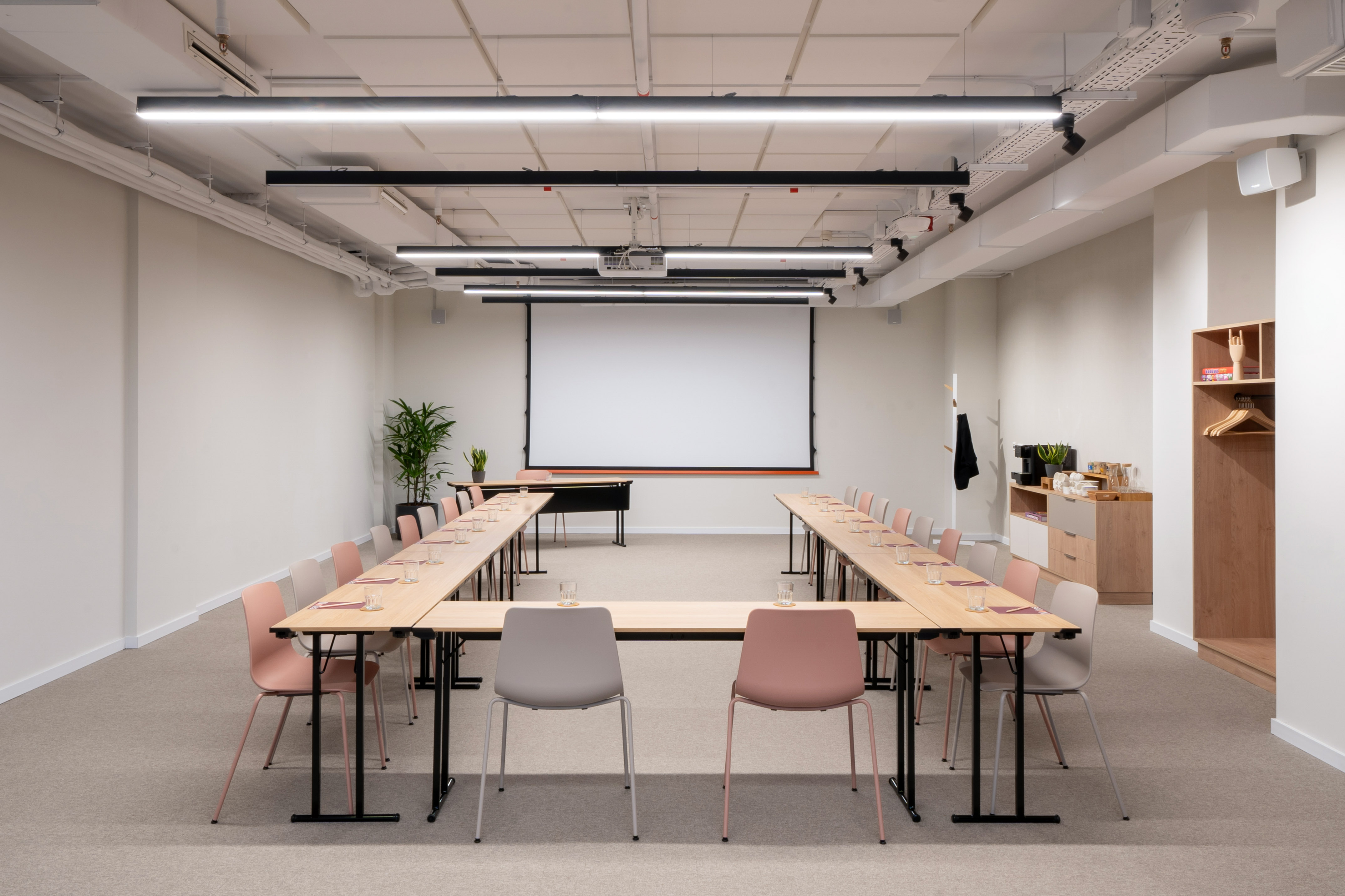 Modern U-shape conference room setup with projector screen.
