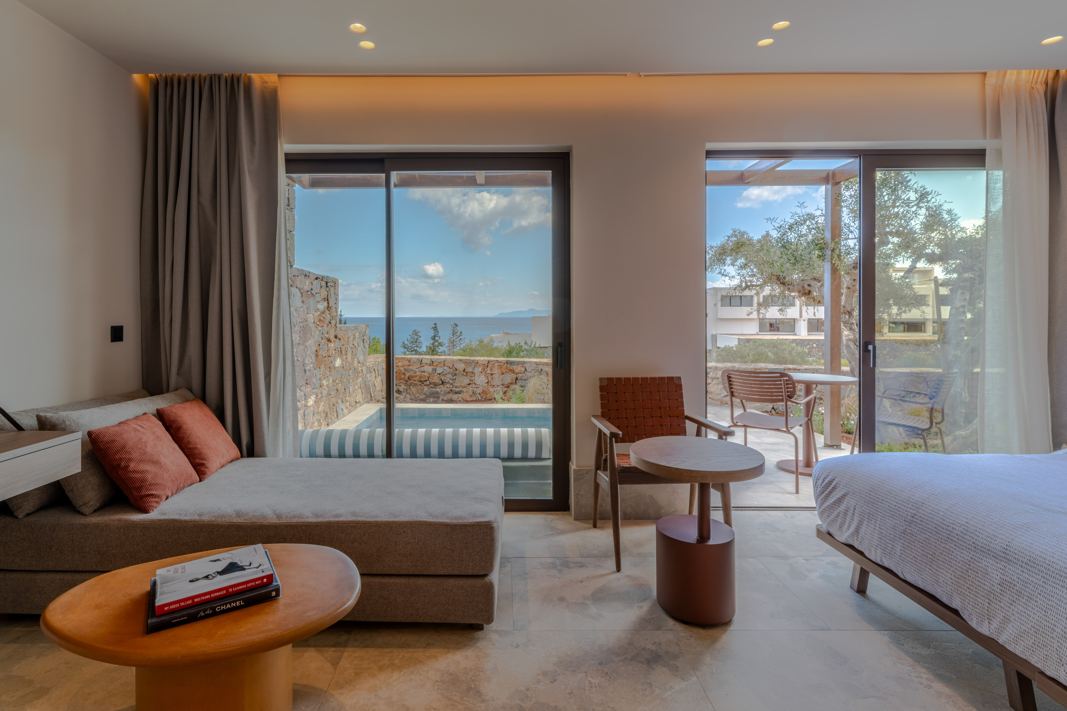 Modern hotel suite with sea view, private plunge pool, and outdoor terrace.