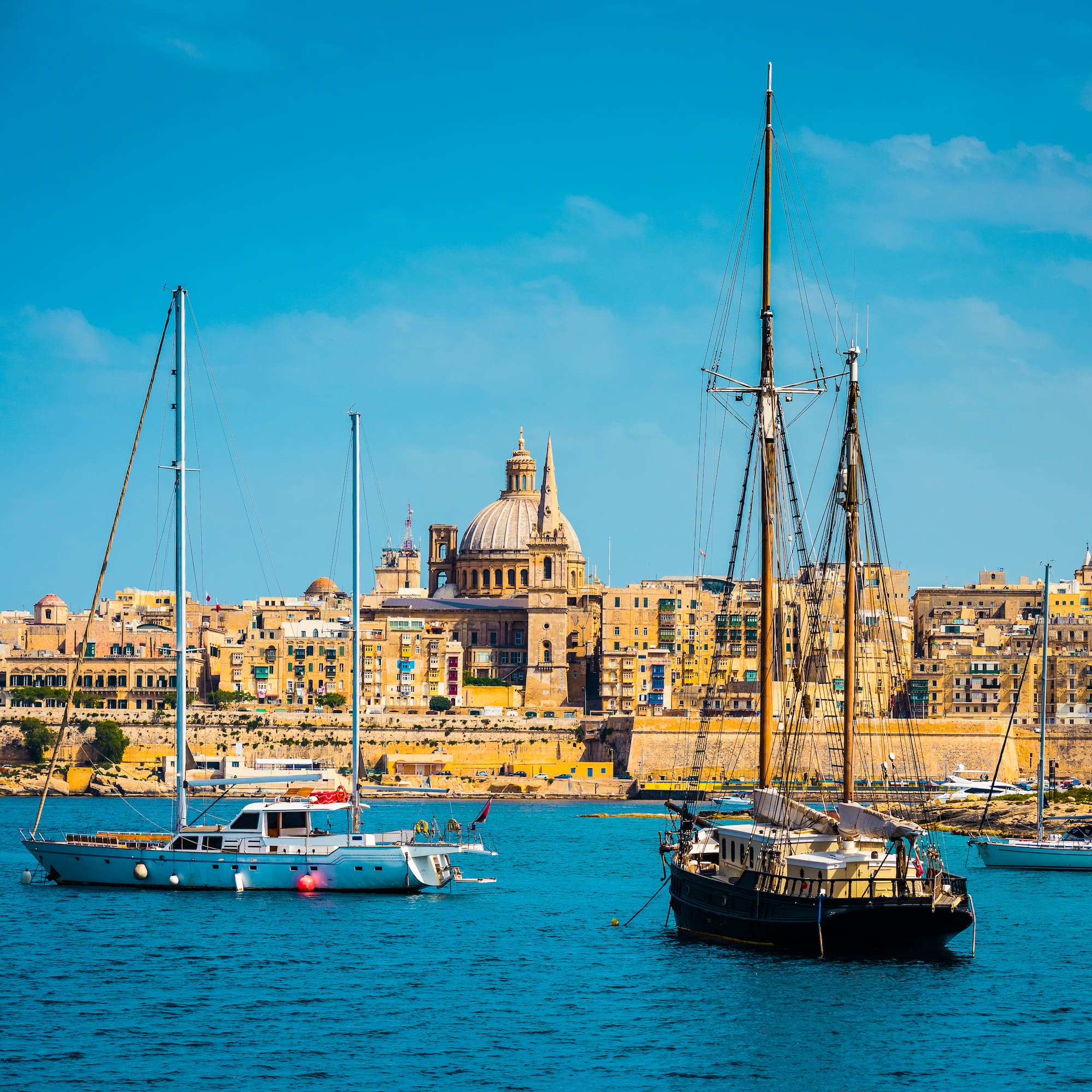 Valletta, Malta: historic city skyline, St. Paul's dome, and yachts in harbor.