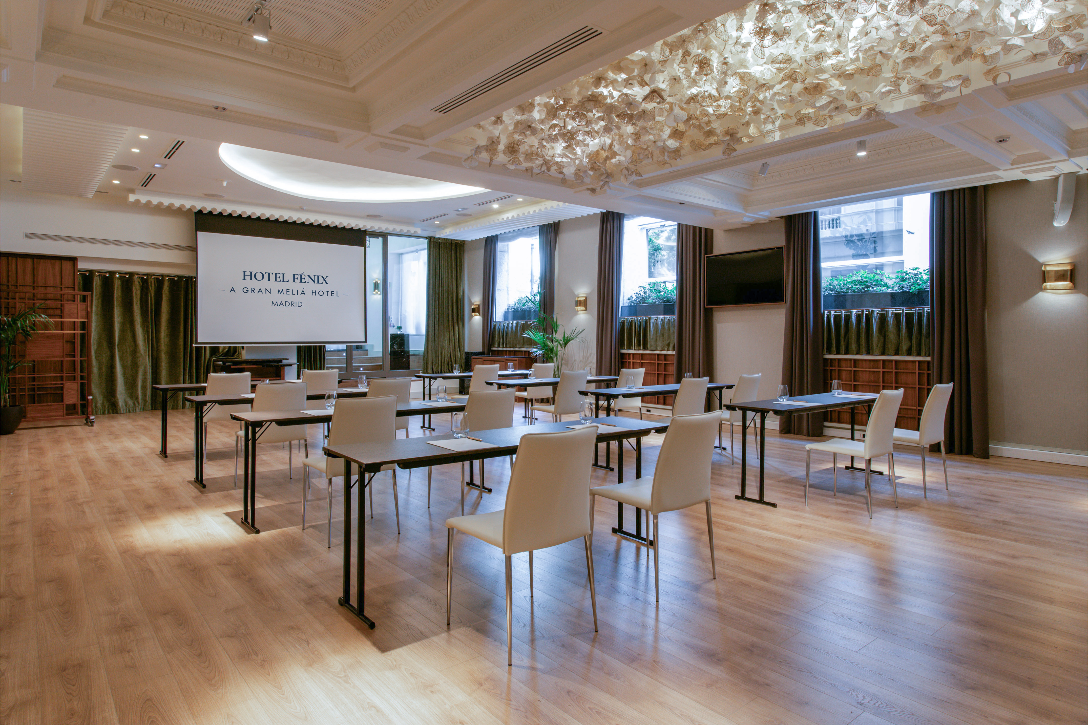 Hotel Fenix Madrid meeting room with projector screen and rows of tables.