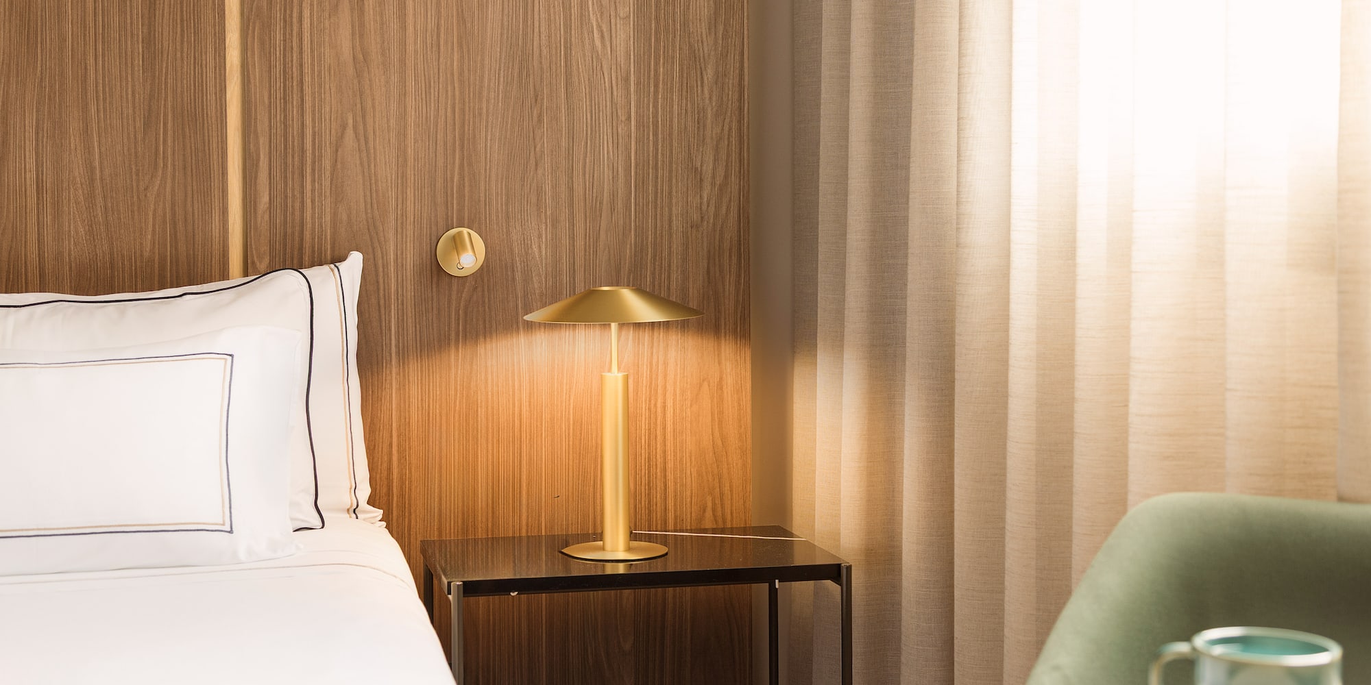 a bed with a lamp on a table