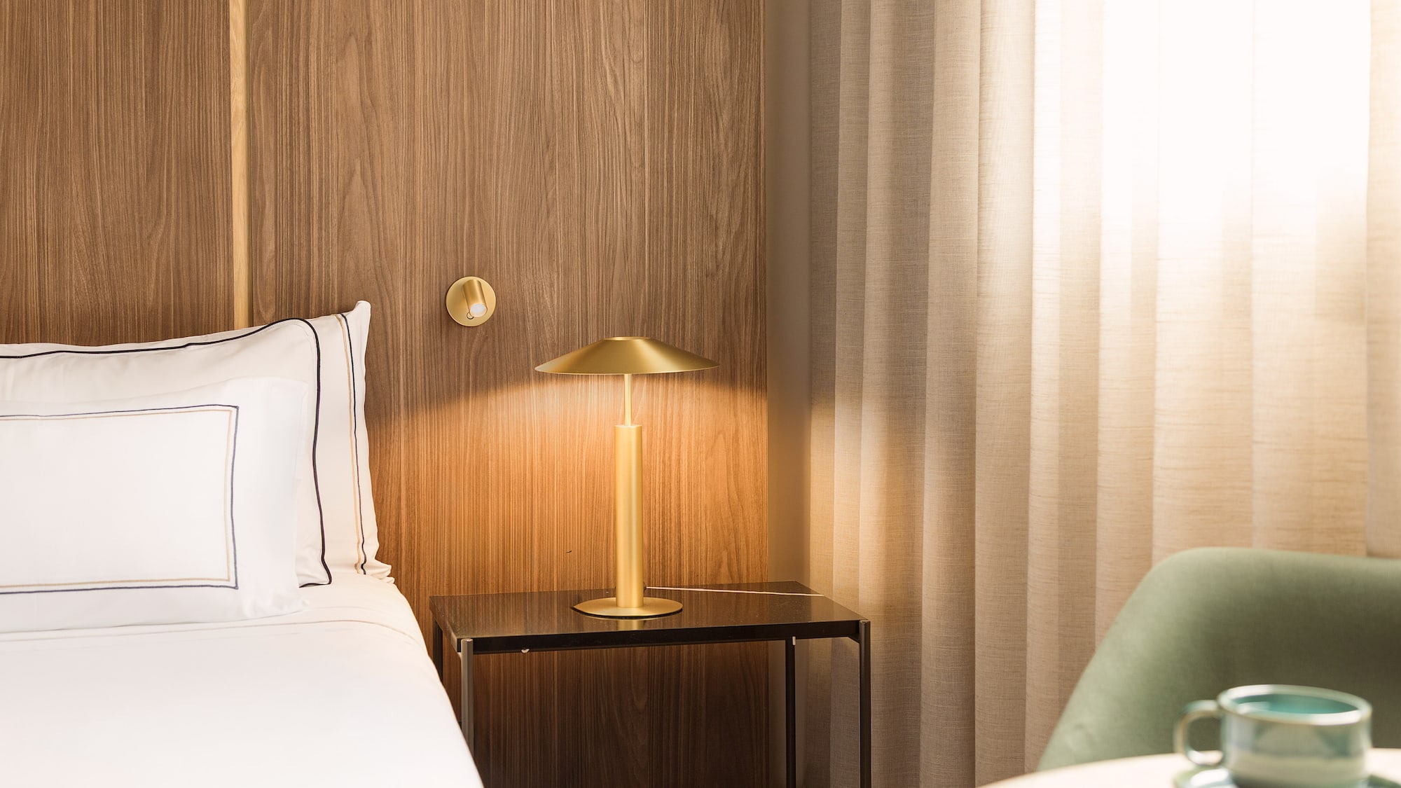 a bed with a lamp on a table