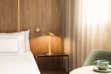 a bed with a lamp on a table