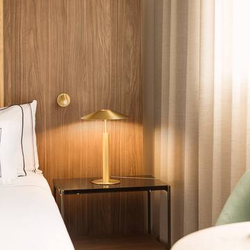 a bed with a lamp on a table