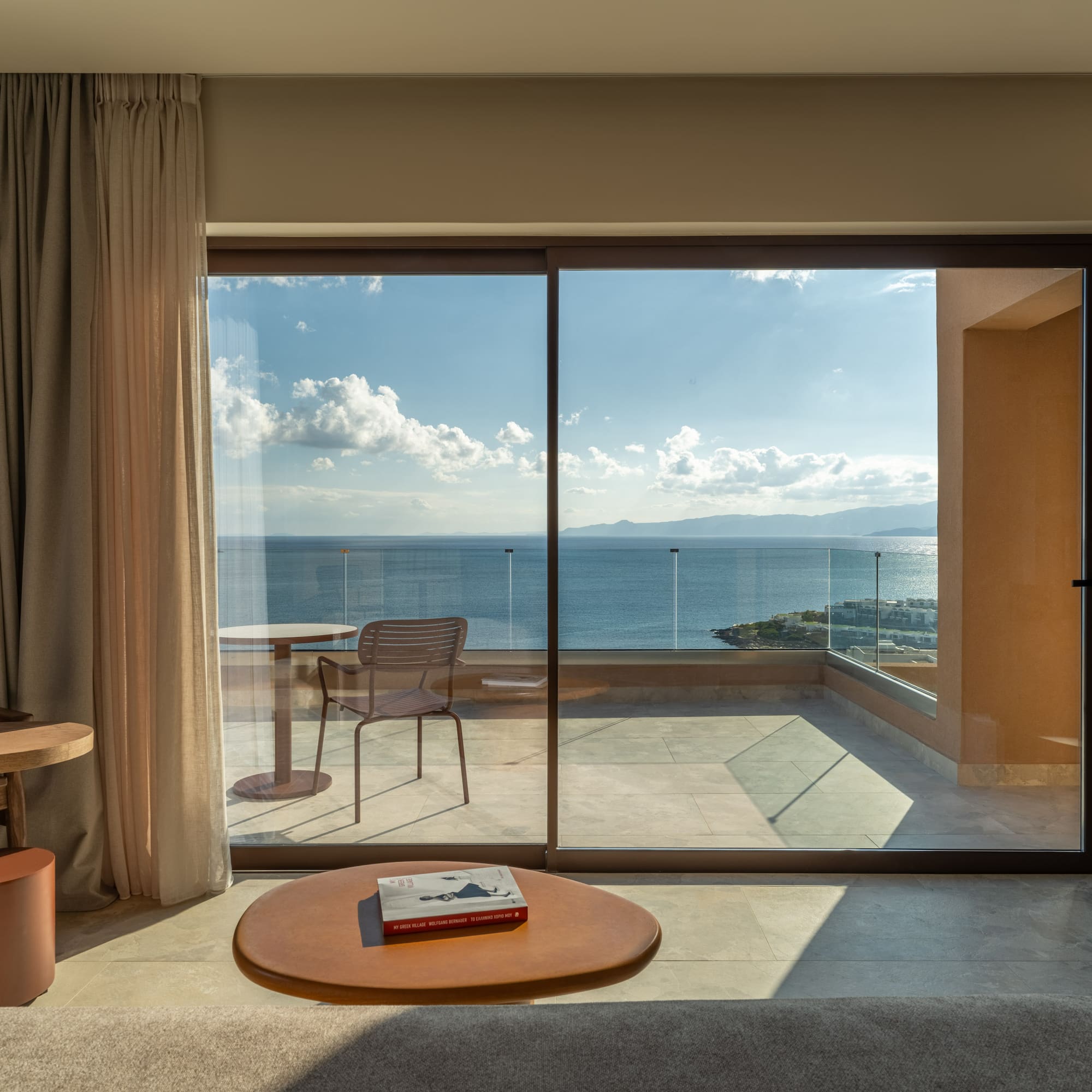 a room with a glass door and a table and chairs