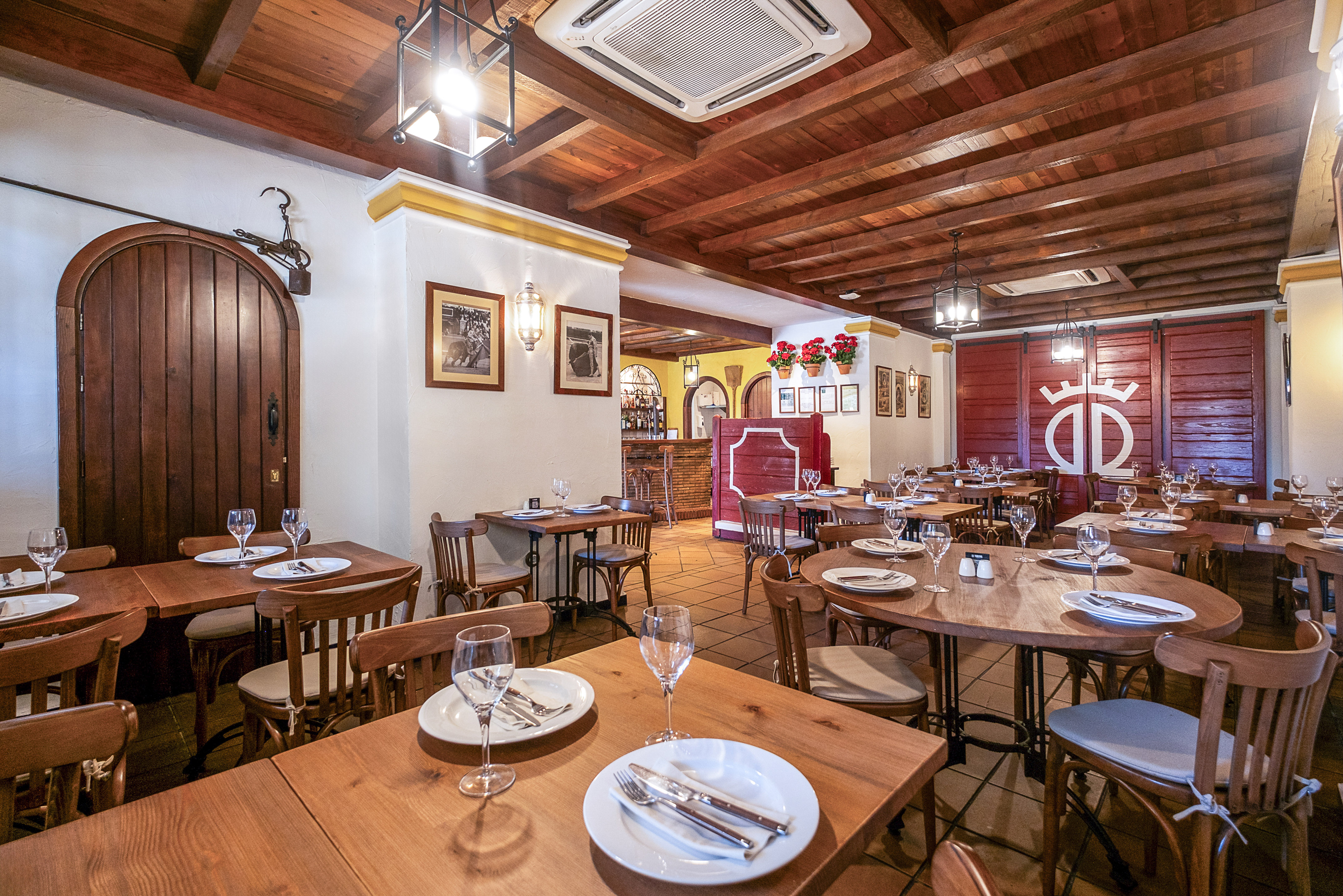 Spanish restaurant dining room with rustic wooden tables and chairs.