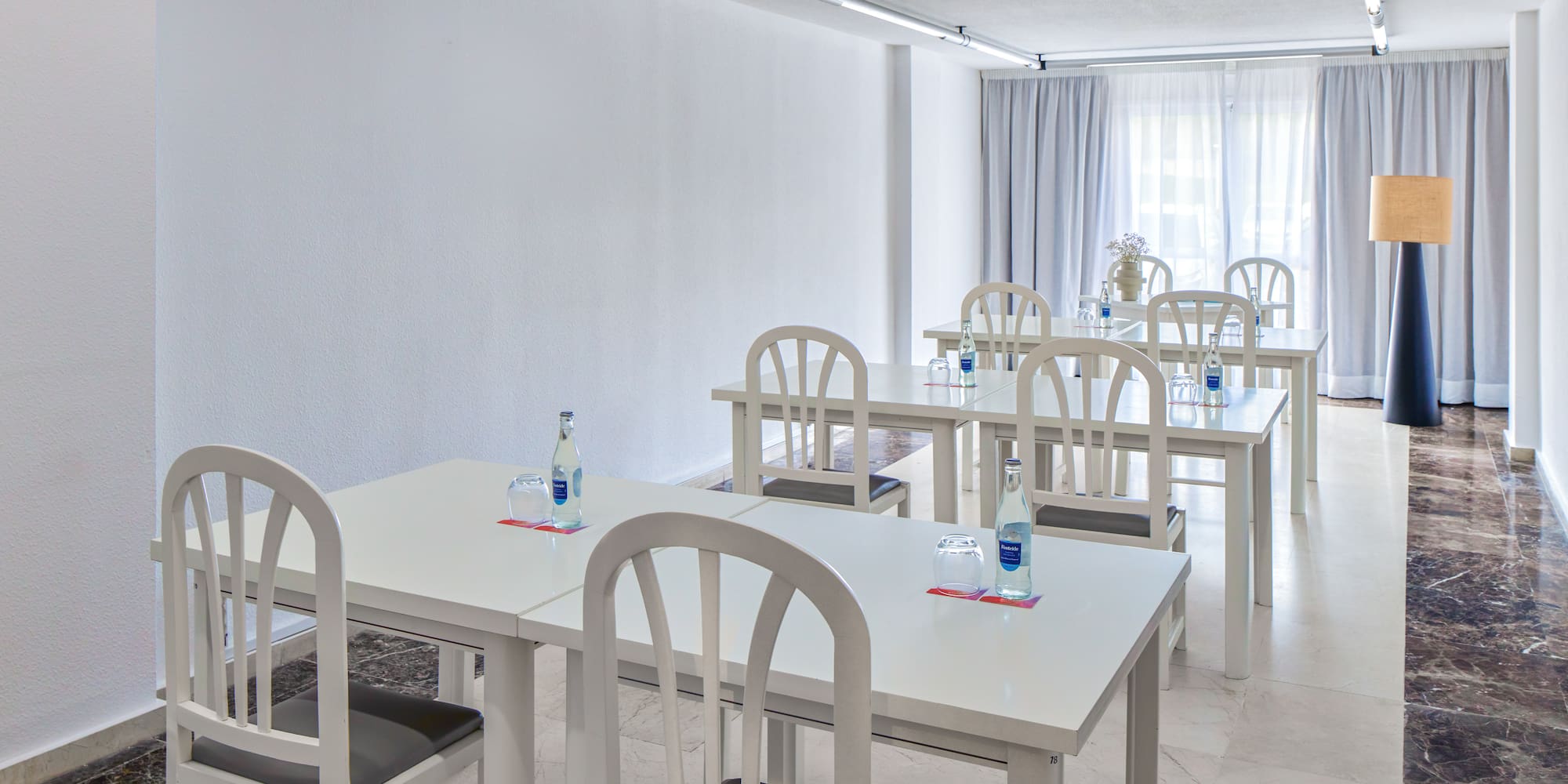 a room with white tables and chairs