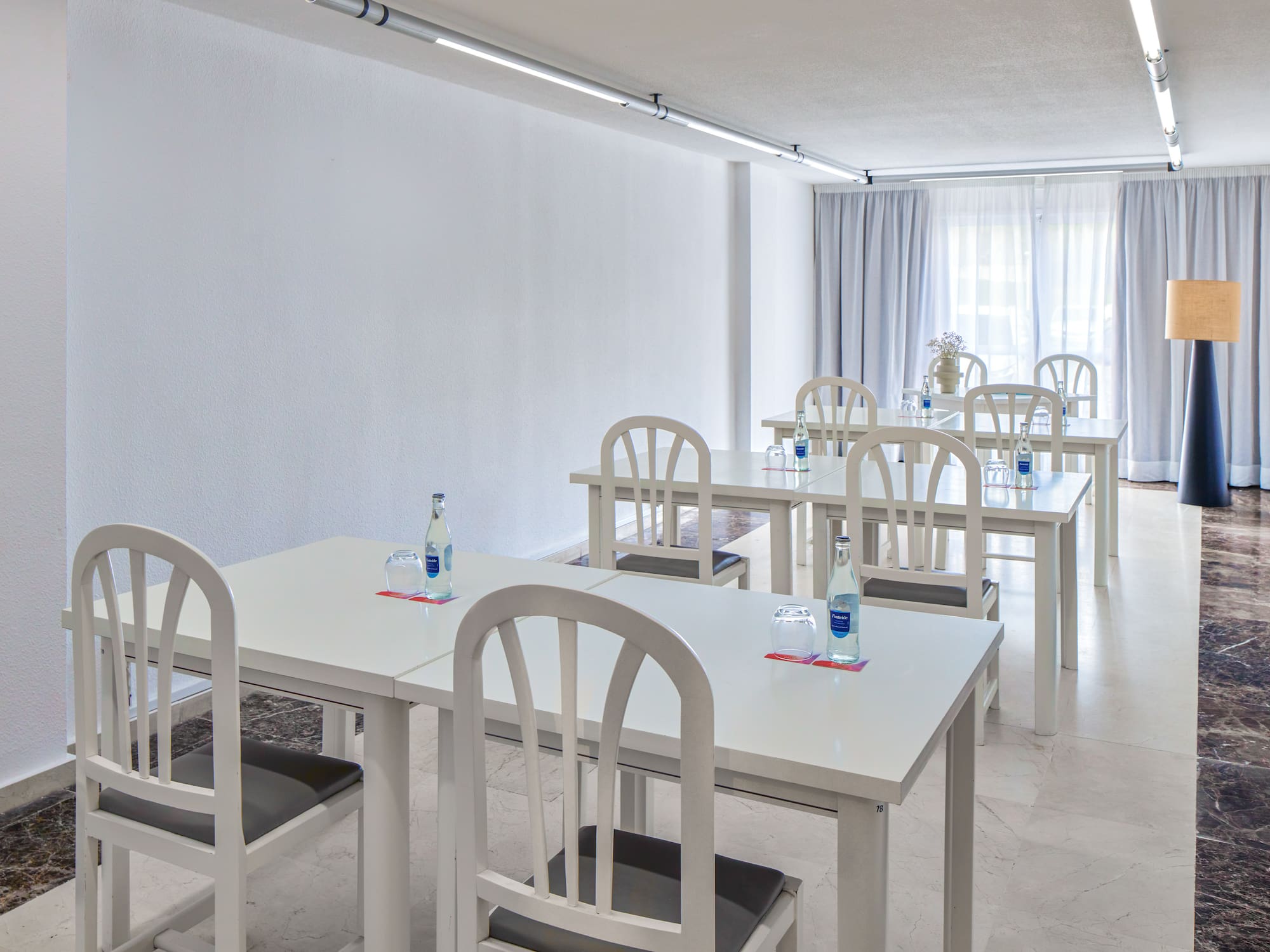 a room with white tables and chairs