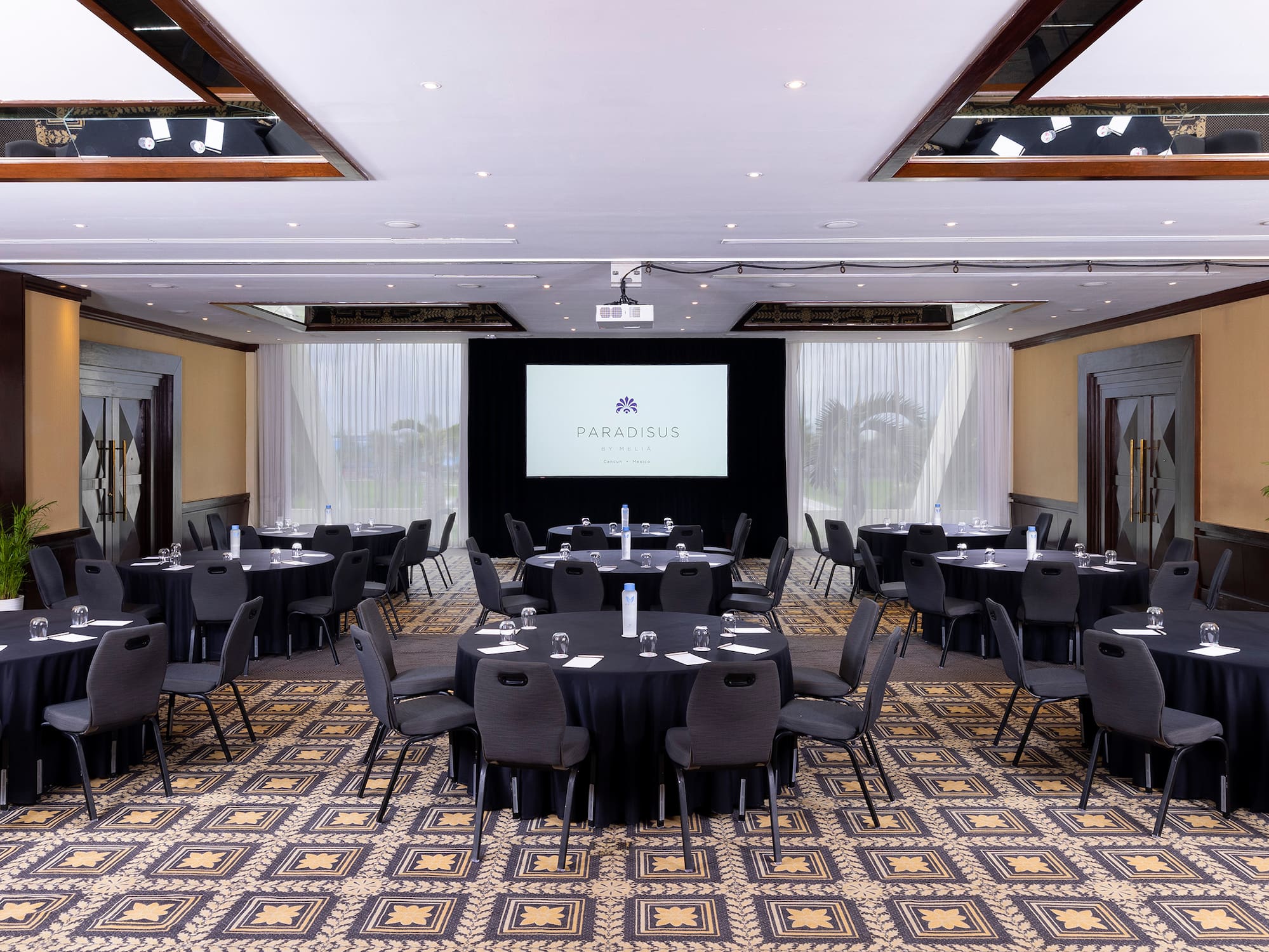 a room with a large screen and tables