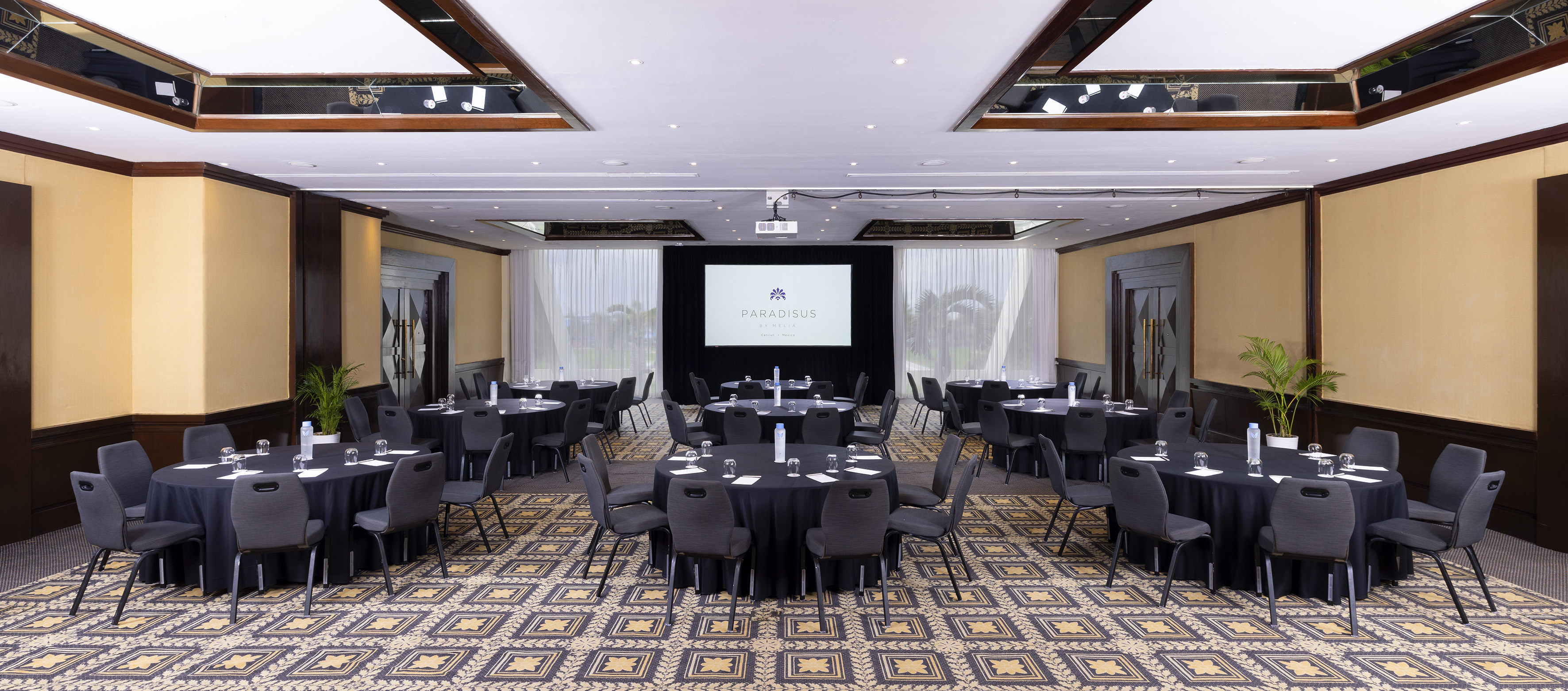 a room with a large screen and tables