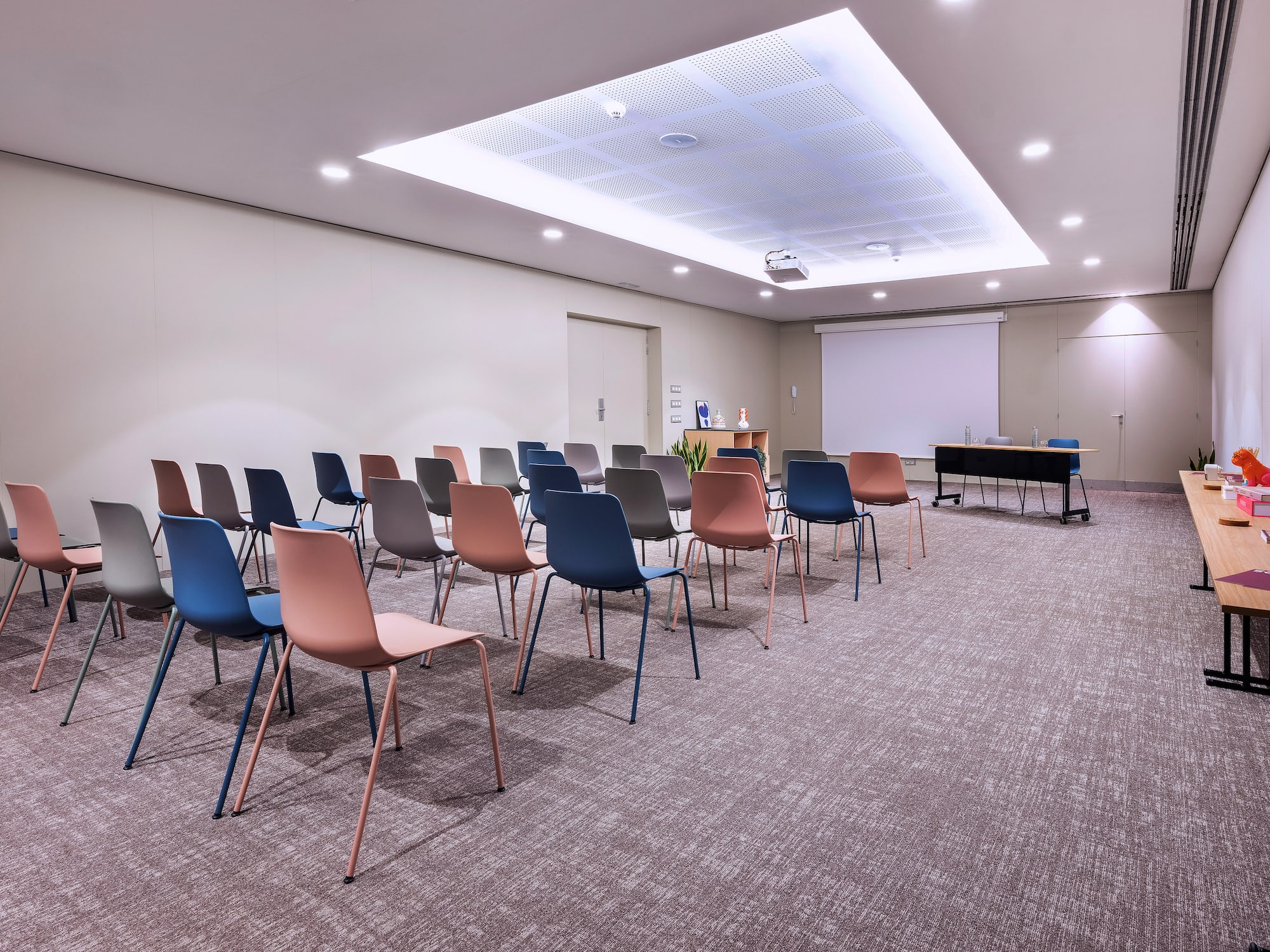 a room with many chairs and a projector screen