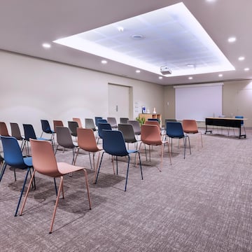 a room with many chairs and a projector screen